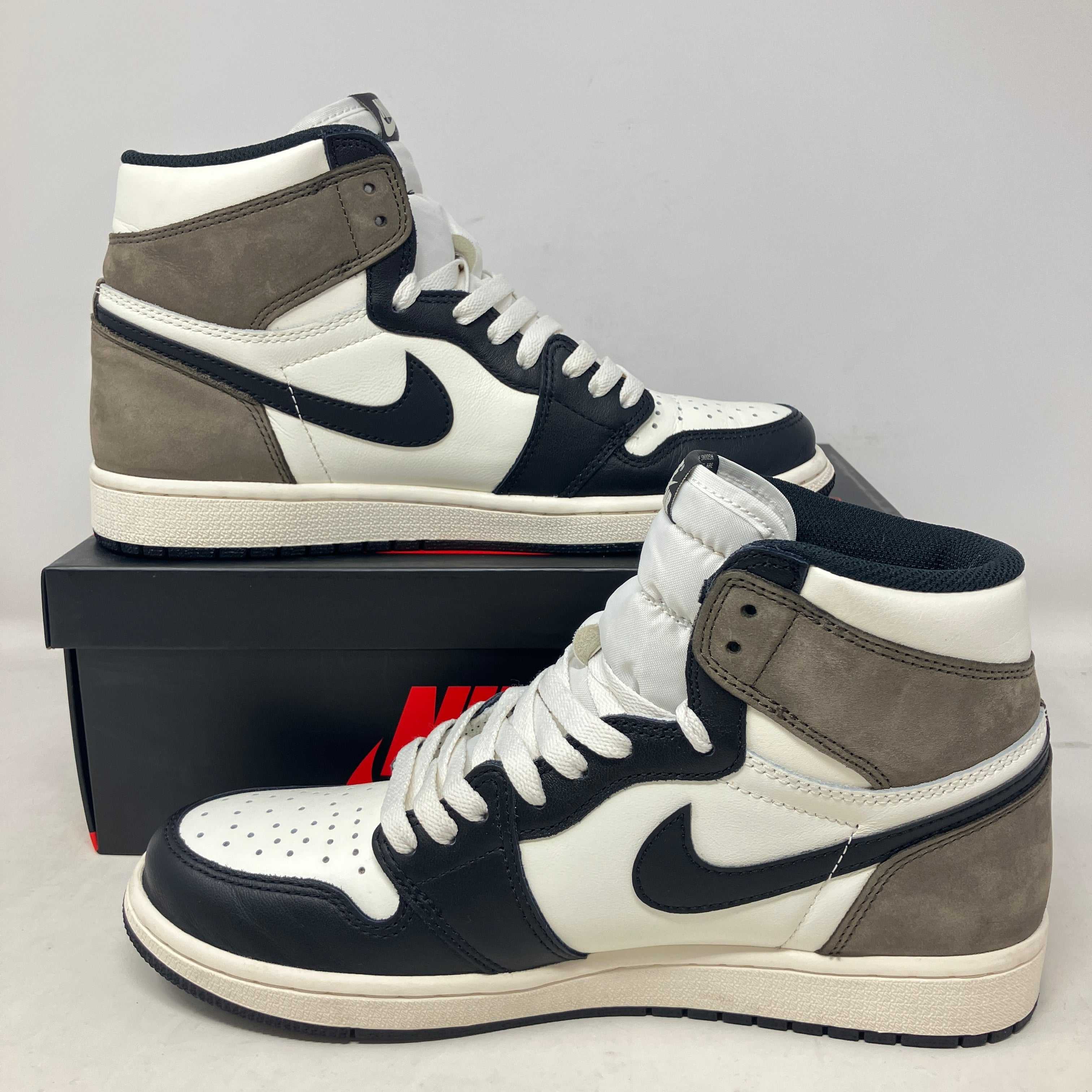 Black, white, and grey Air Jordan 1 sneakers displayed on a black and red Nike shoebox, highlighting sneaker culture and Sneaker Con Los Angeles event.