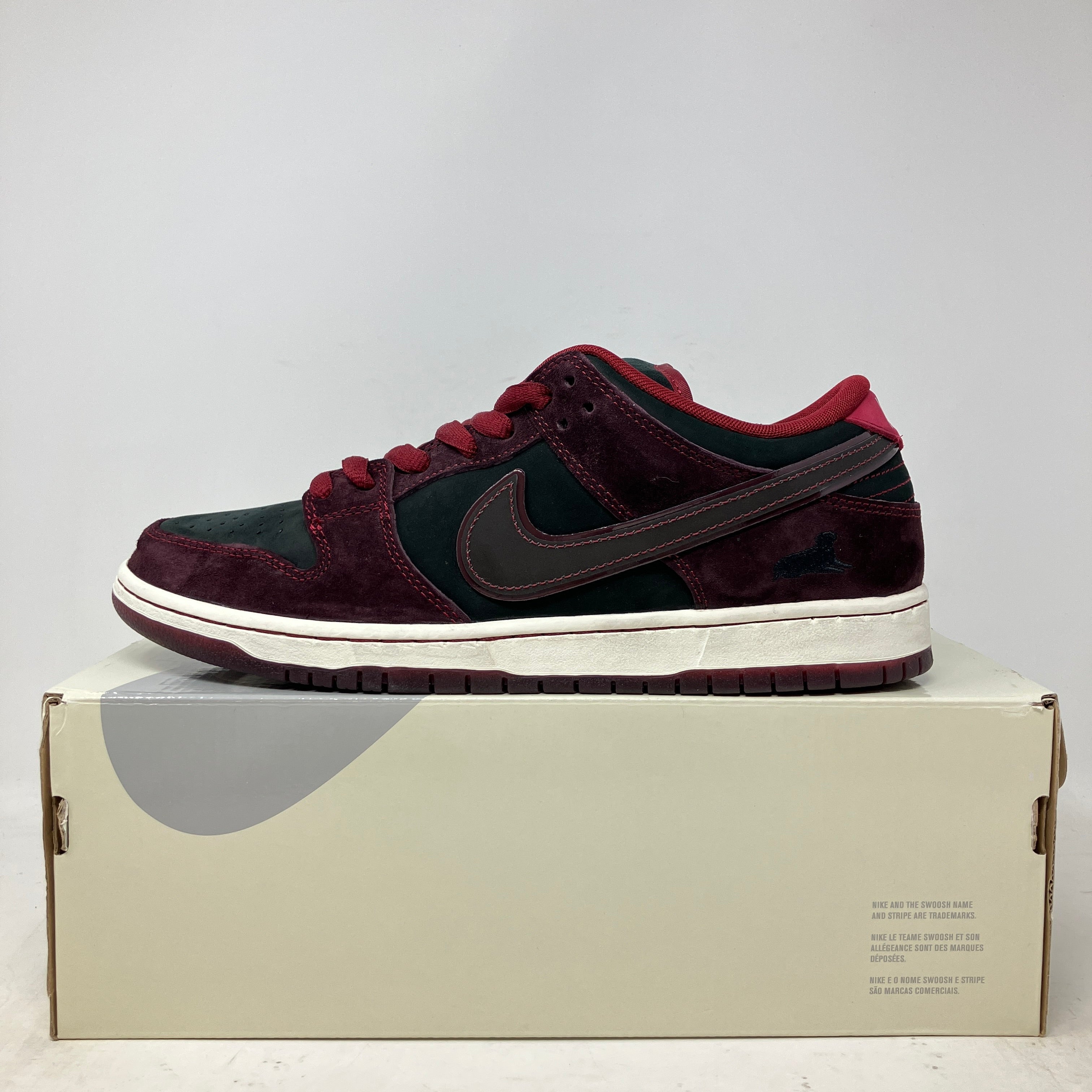 Nike SB Dunk Low Riot Skateshop sneaker in black and dark red on a shoebox, brand new with all accessories included