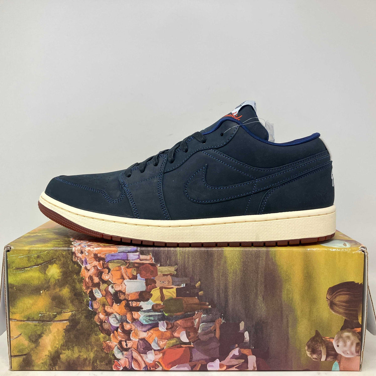Jordan 1 Low golf sneaker in dark navy suede with tonal stitching, a cream midsole and brown gum outsole.