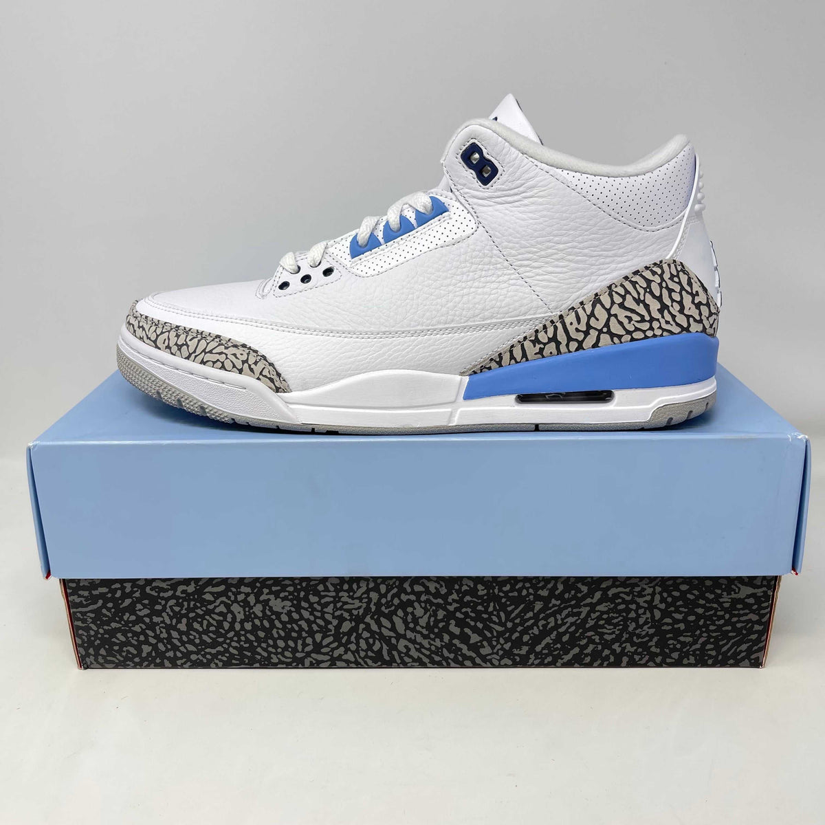 Jordan 3 Retro UNC sneaker in white leather with light blue accents and elephant print detailing on sole and sides.