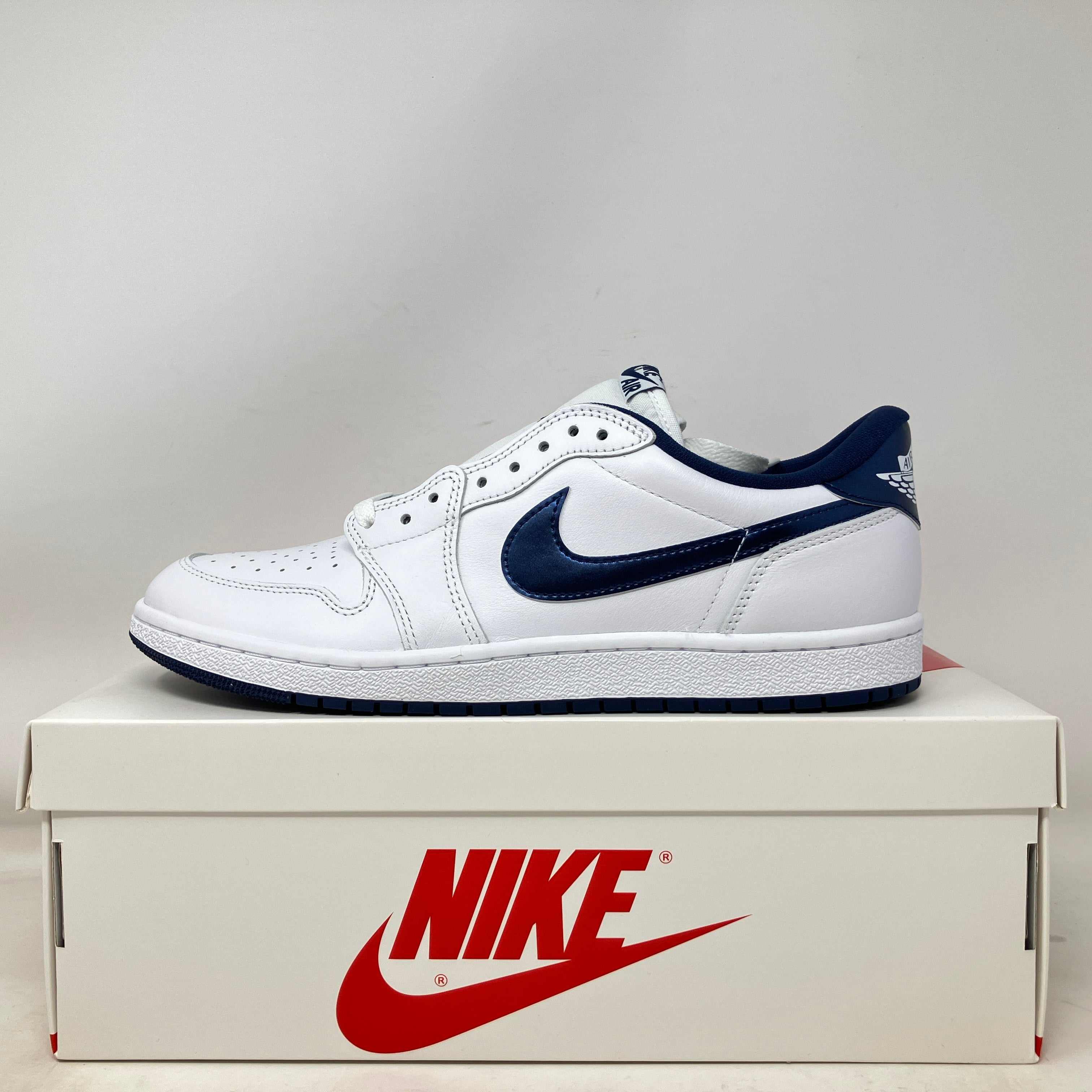White and metallic blue Jordan 1 Retro Low sneaker on Nike box, brand new with accessories included