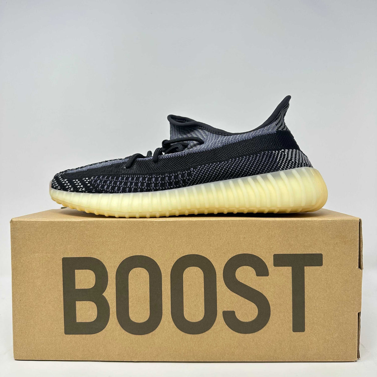 adidas Yeezy Boost 350 V2 black and grey knit sneaker with translucent cream sole and textured pattern on the side