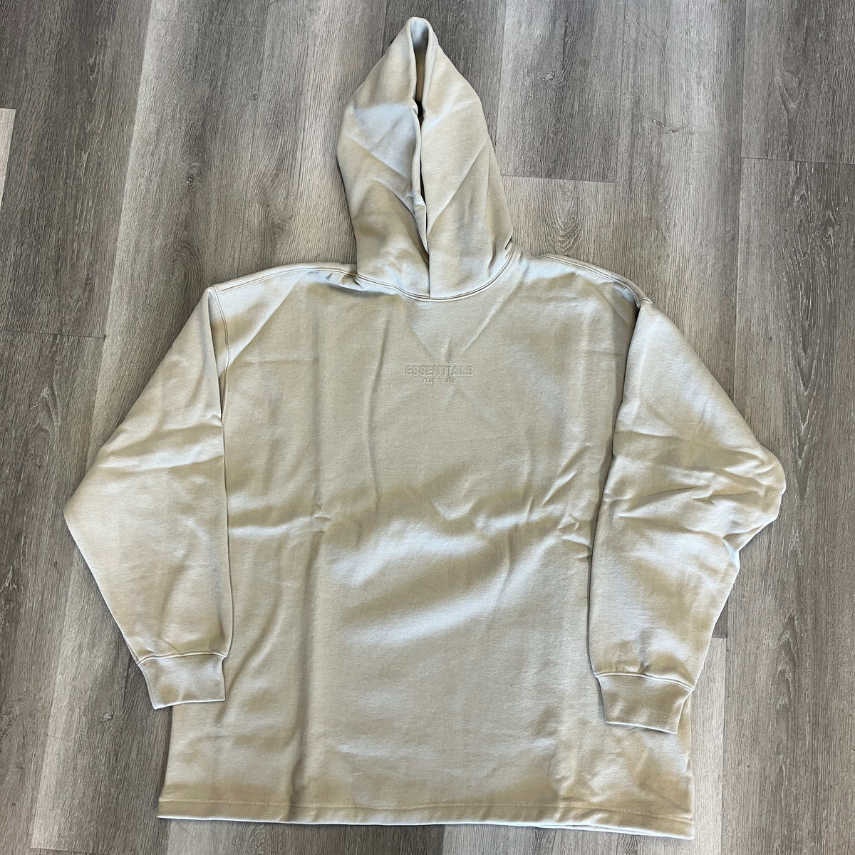 Fear of God Essentials relaxed hoodie in smoke color, soft cotton material with a roomy fit and embossed logo on chest