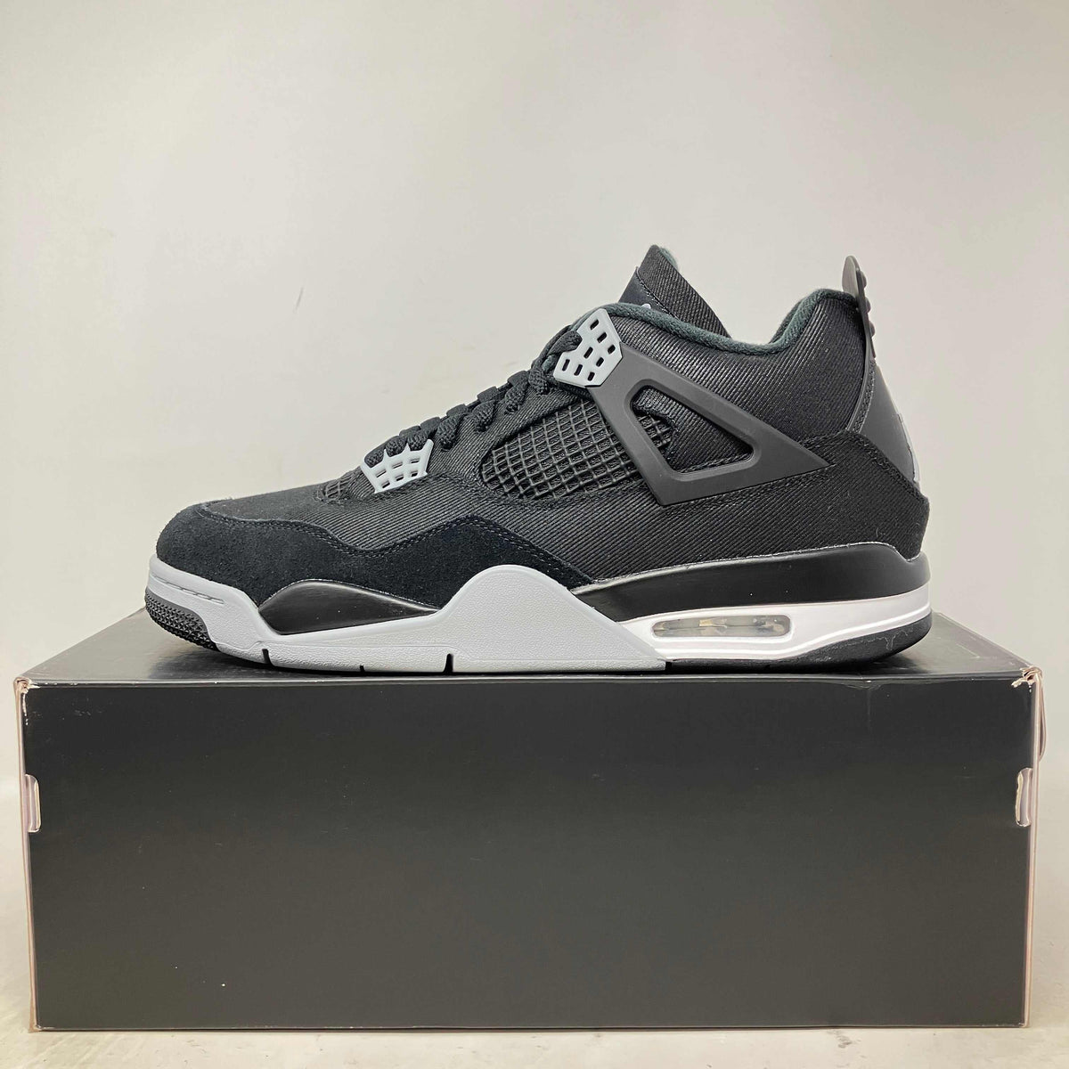 Jordan 4 Retro SE black canvas sneaker with grey and white accents, mesh side panels, and visible air sole unit.