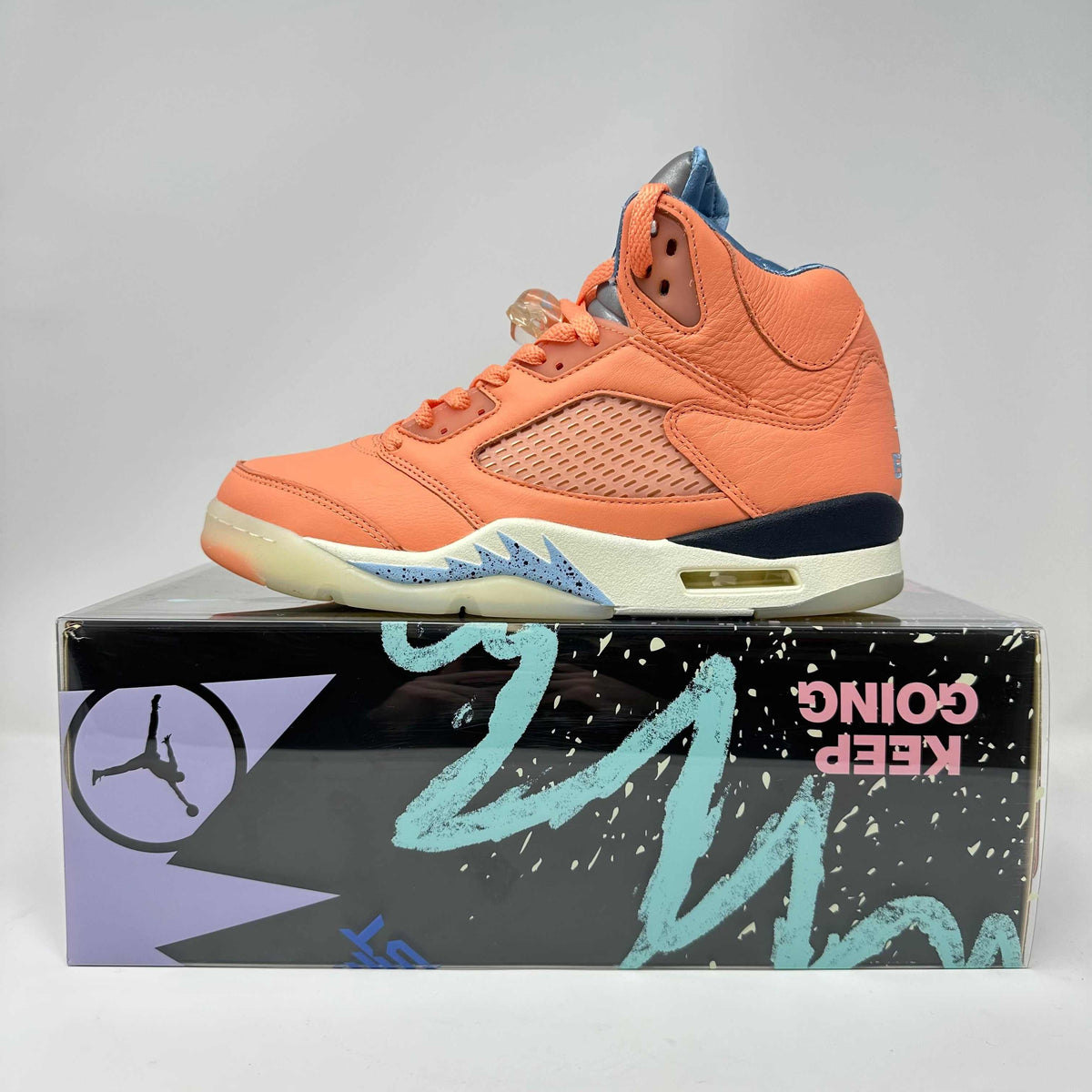 Jordan 5 Retro basketball shoe in orange leather with blue and cream sole accents and a translucent lace lock