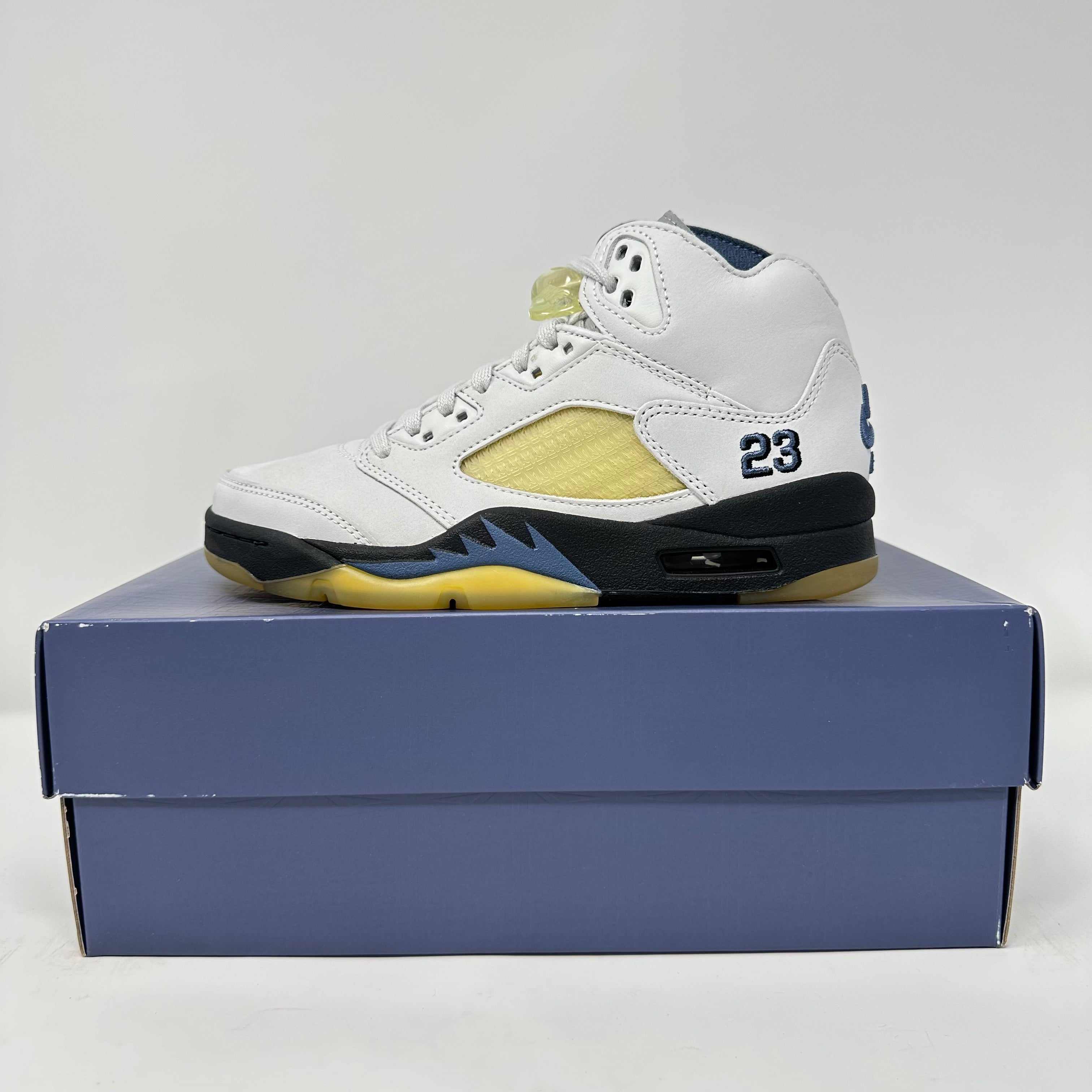 Jordan 5 Retro A Ma Maniére Dawn sneaker in white with navy and yellow accents on blue shoebox