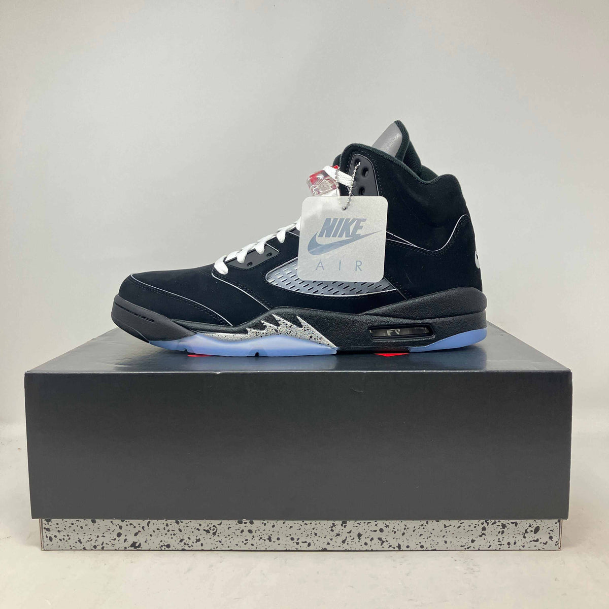 Jordan 5 Retro OG black suede sneaker with metallic silver accents, white laces, and translucent blue sole displayed on box