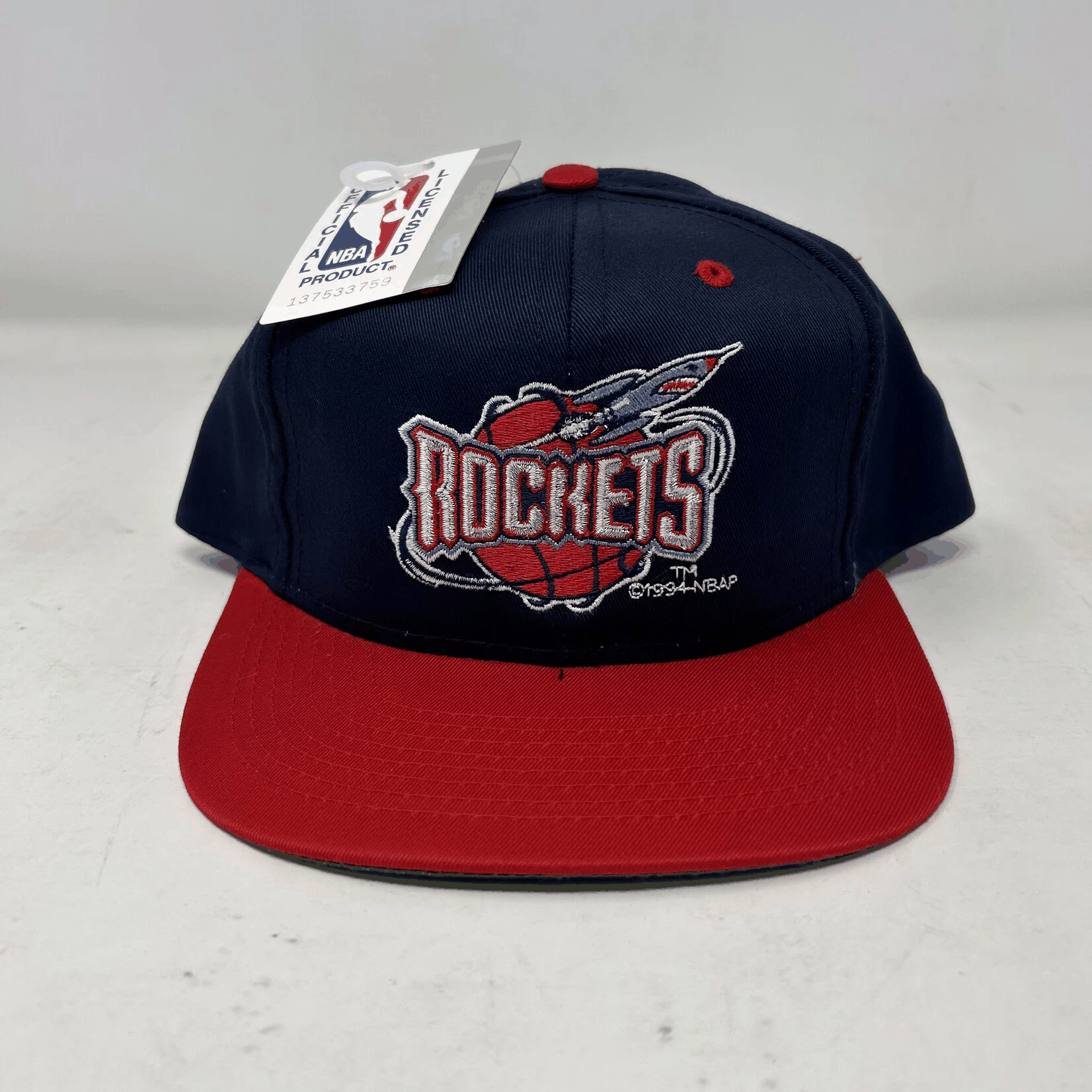 Vintage Houston Rockets snapback cap with navy crown and red brim, featuring 1994 Rockets logo and NBA tag