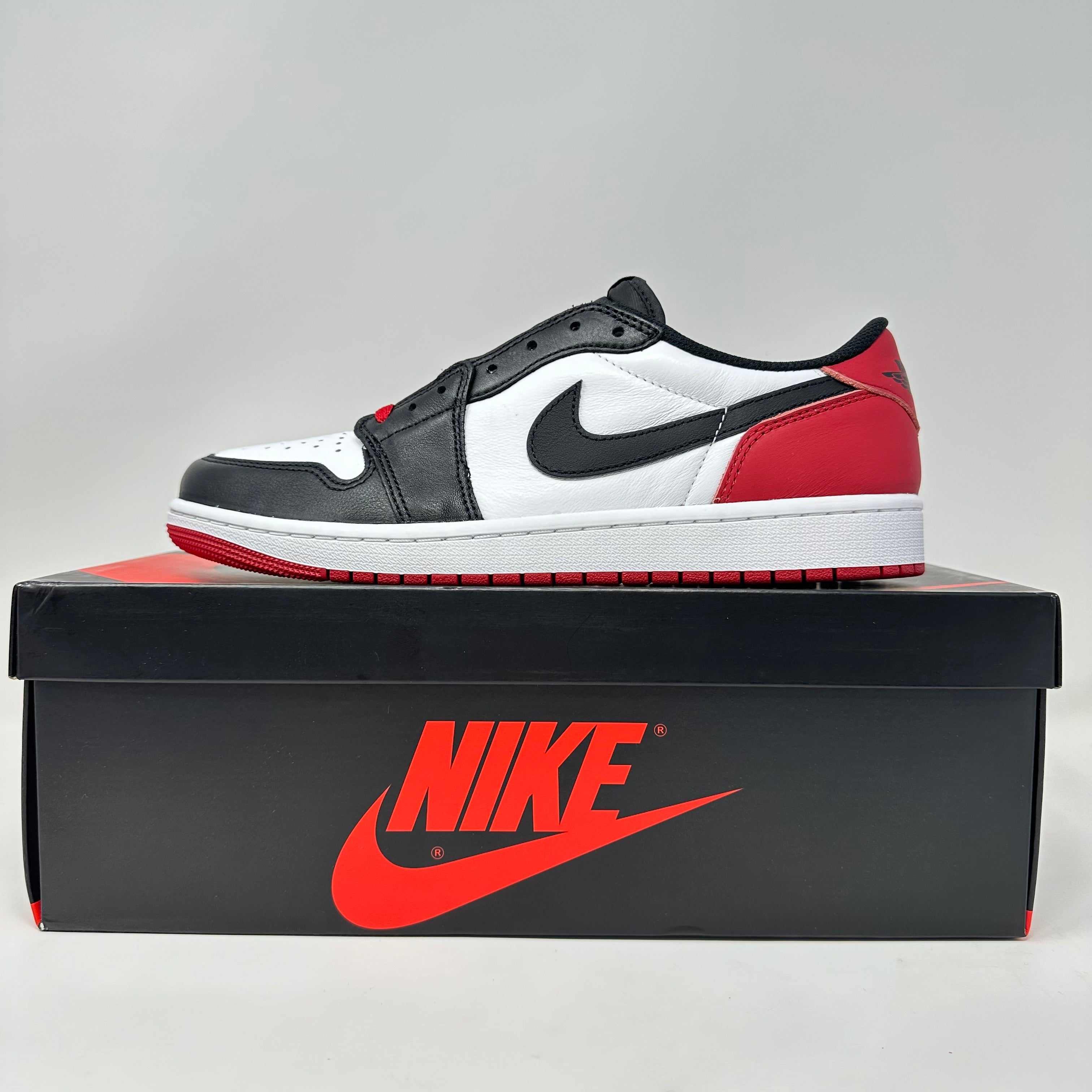 Jordan 1 Retro Low OG Black Toe sneaker in black, white, and red on Nike box, brand new with all accessories