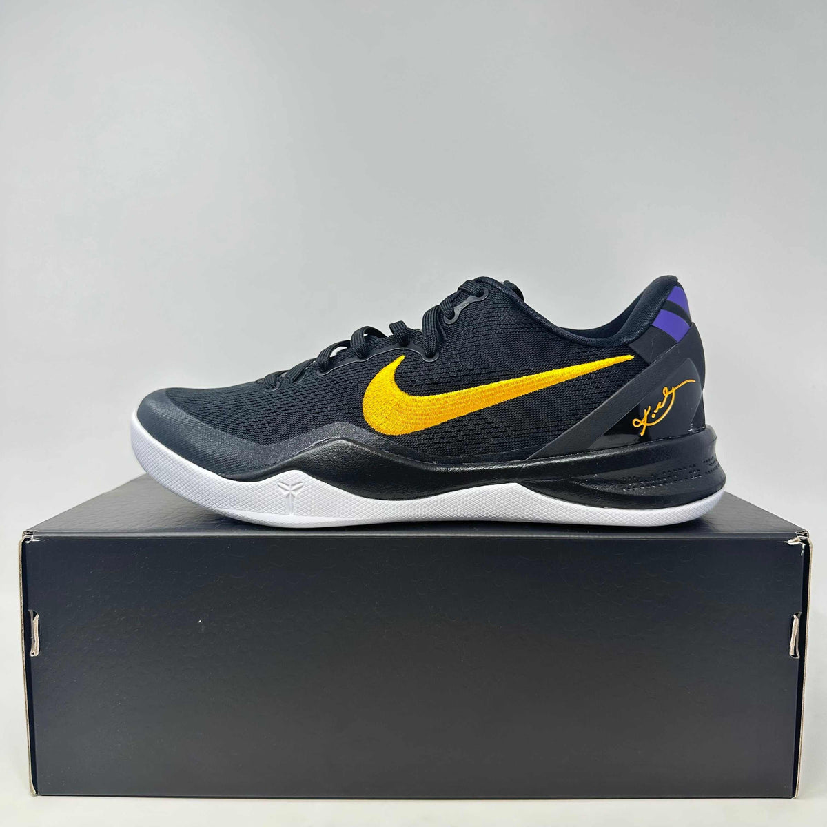 Nike Kobe 8 Protro black basketball shoe with yellow Swoosh, purple accents, signature detail, and white sole on black box.