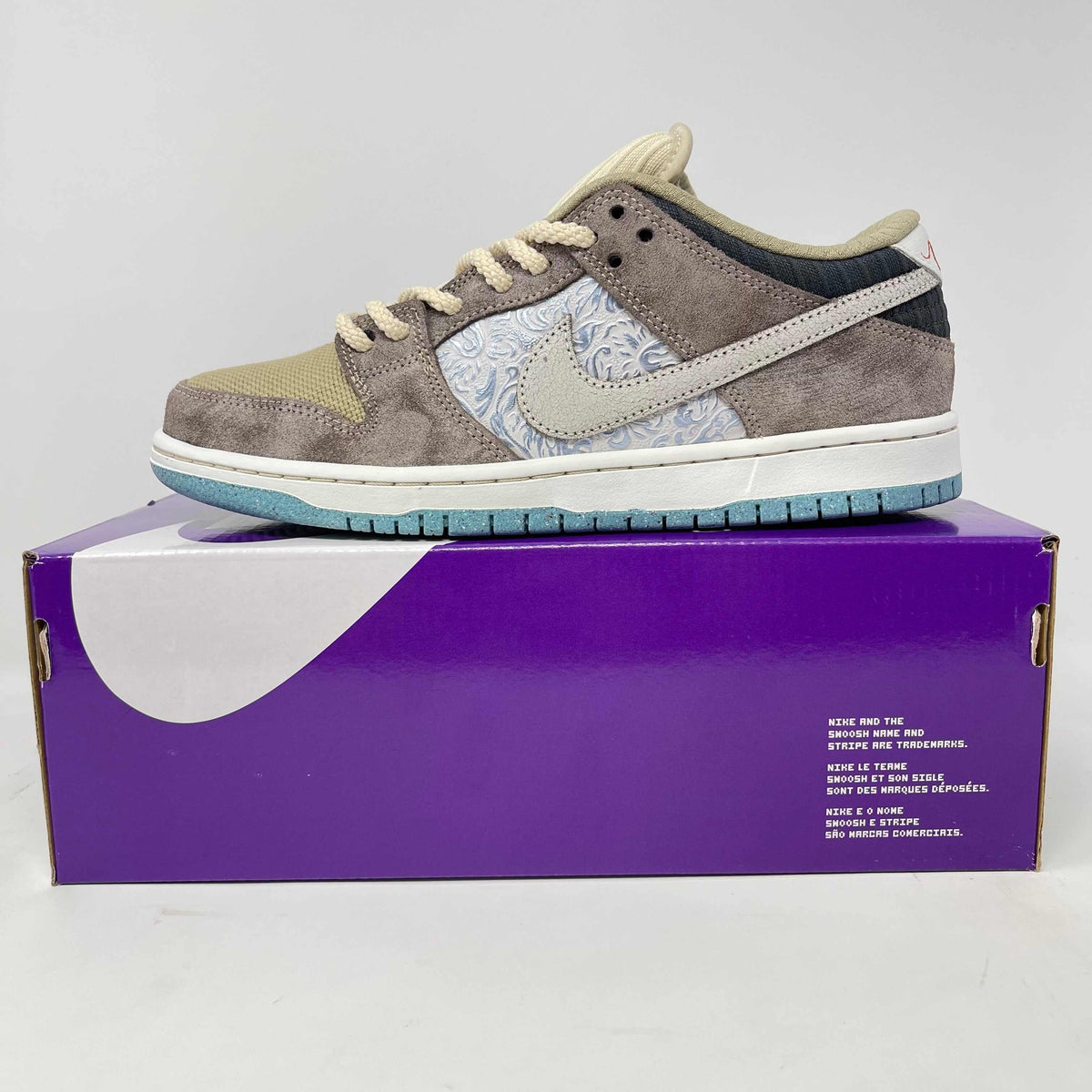 Nike SB Dunk Low sneaker in taupe suede with pale blue paisley panels, cream laces, a Swoosh and aqua outsole