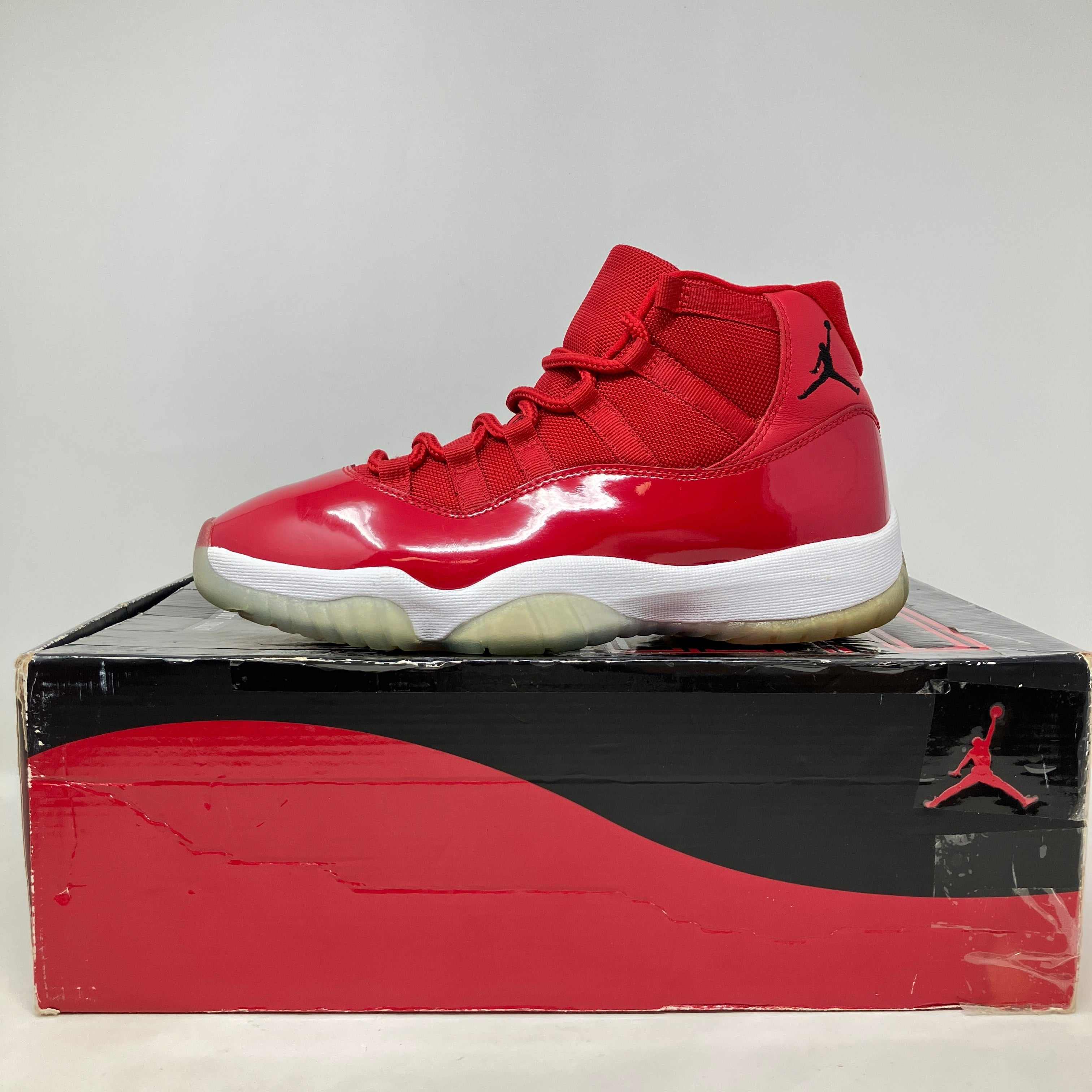 Red Jordan 11 Retro Win Like 96 sneaker on original box, pre-owned condition with accessories included