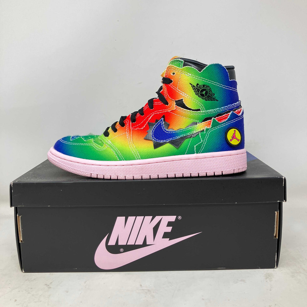 Jordan 1 Retro High sneaker with a vivid multicolour gradient leather upper, blue swoosh, black laces and pink sole.