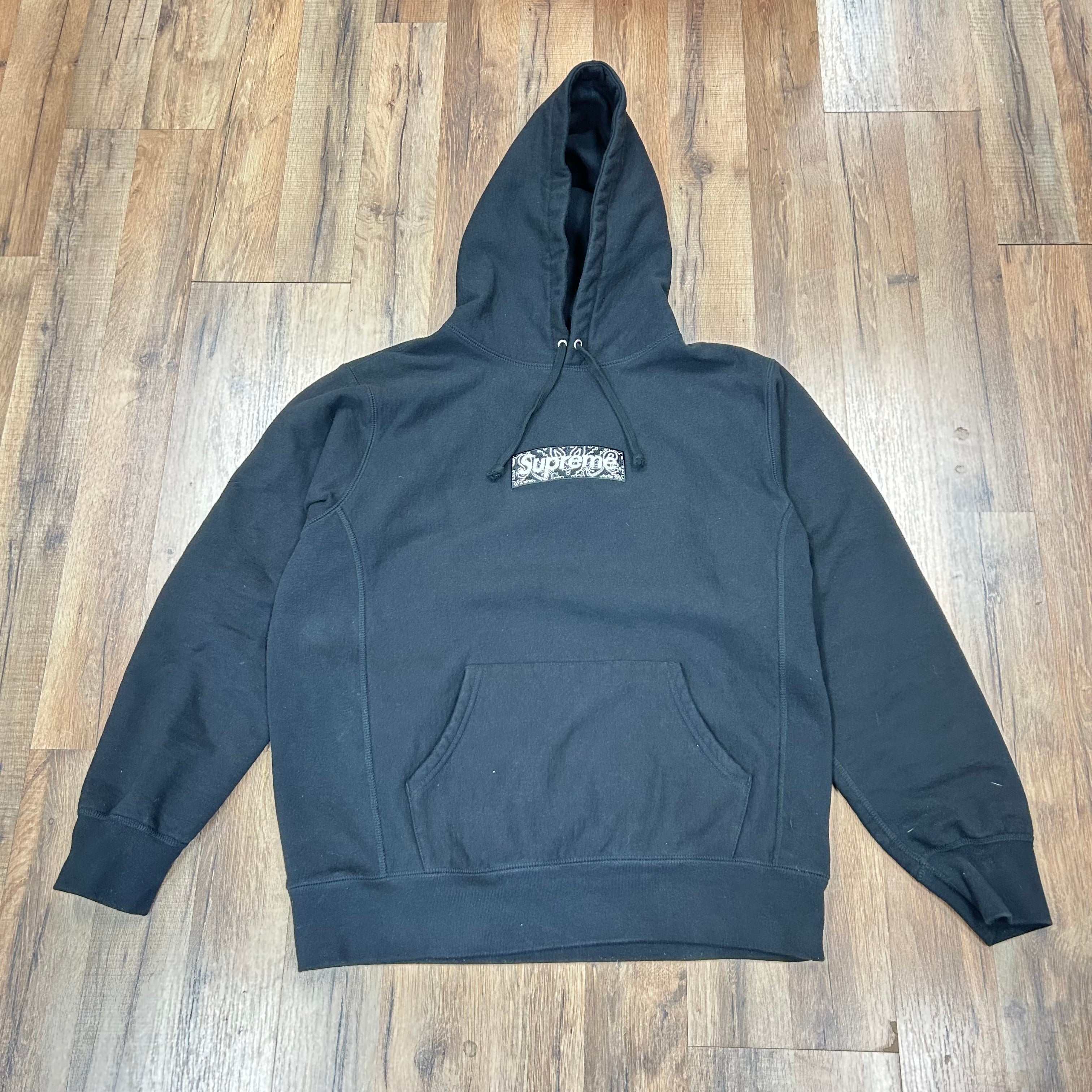 Supreme Bandana Box Logo black hooded sweatshirt with front pocket on wooden floor