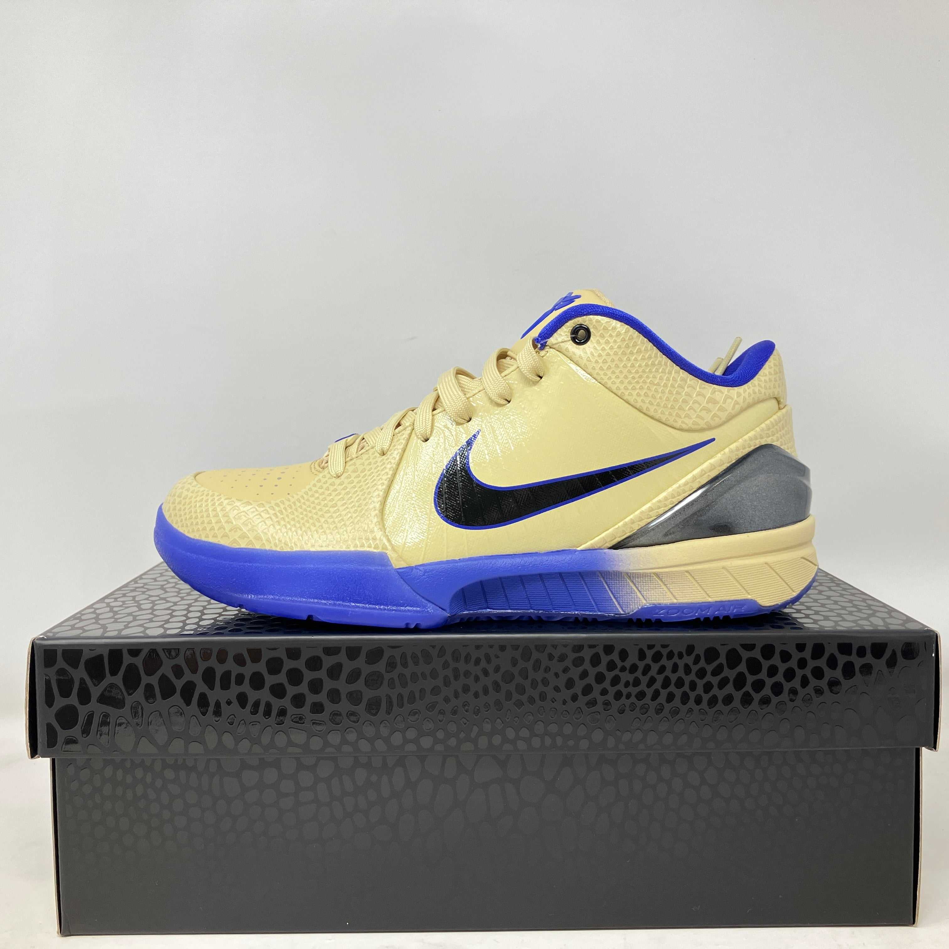 Nike Kobe 4 Protro FC Barcelona Team Gold basketball shoe in beige with blue sole on black patterned box