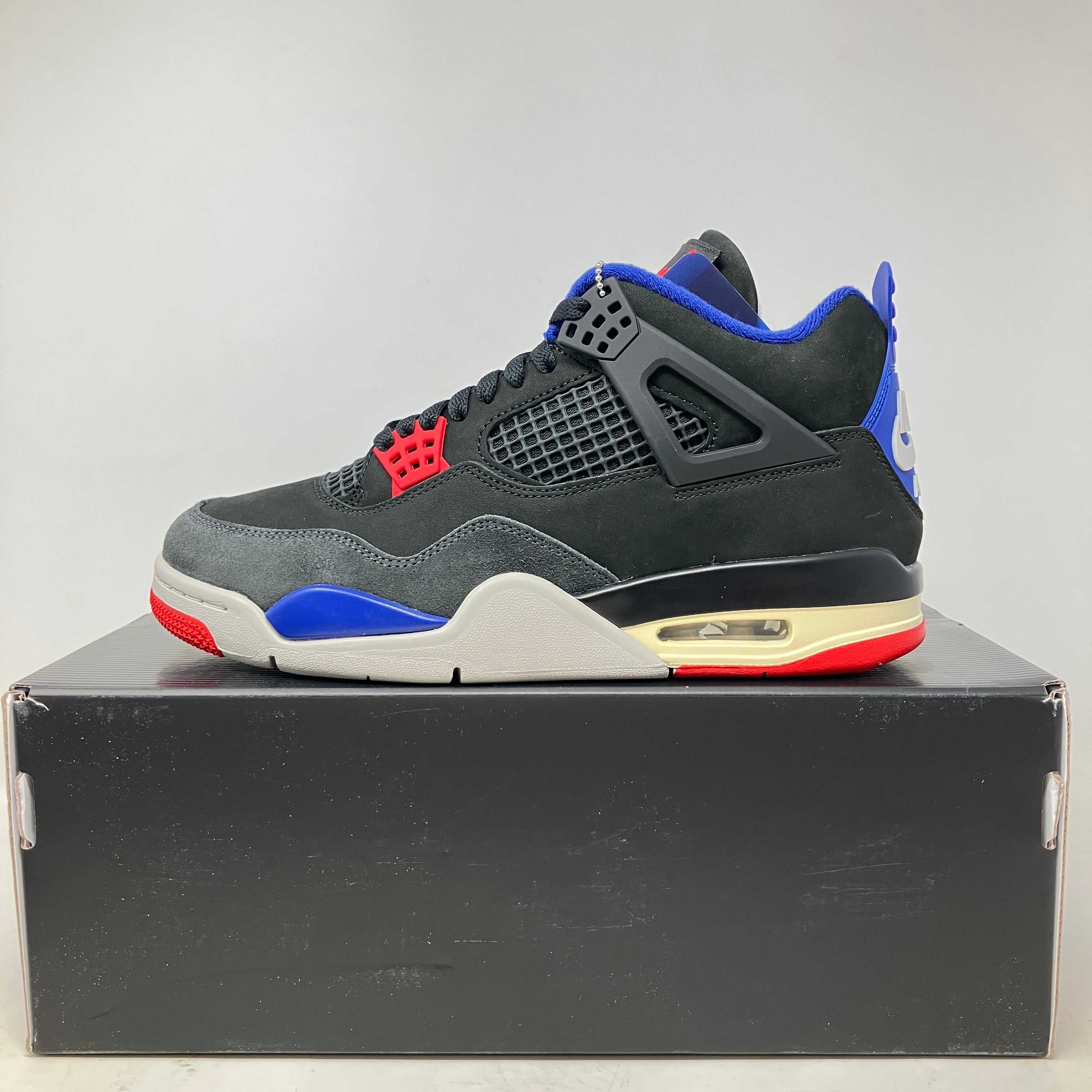 Jordan 4 Retro Rare Air sneaker in black with red, blue, and white accents on black box
