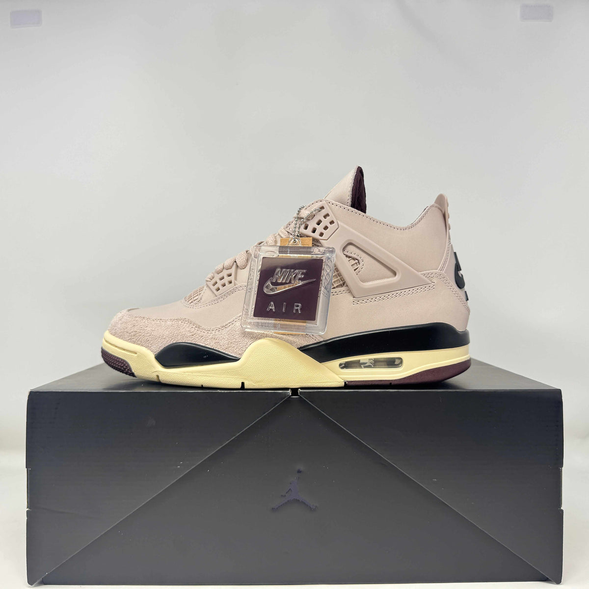 Jordan 4 Retro OG SP sneakers in pale beige suede and leather with black accents, cream-yellow sole and hang tag.