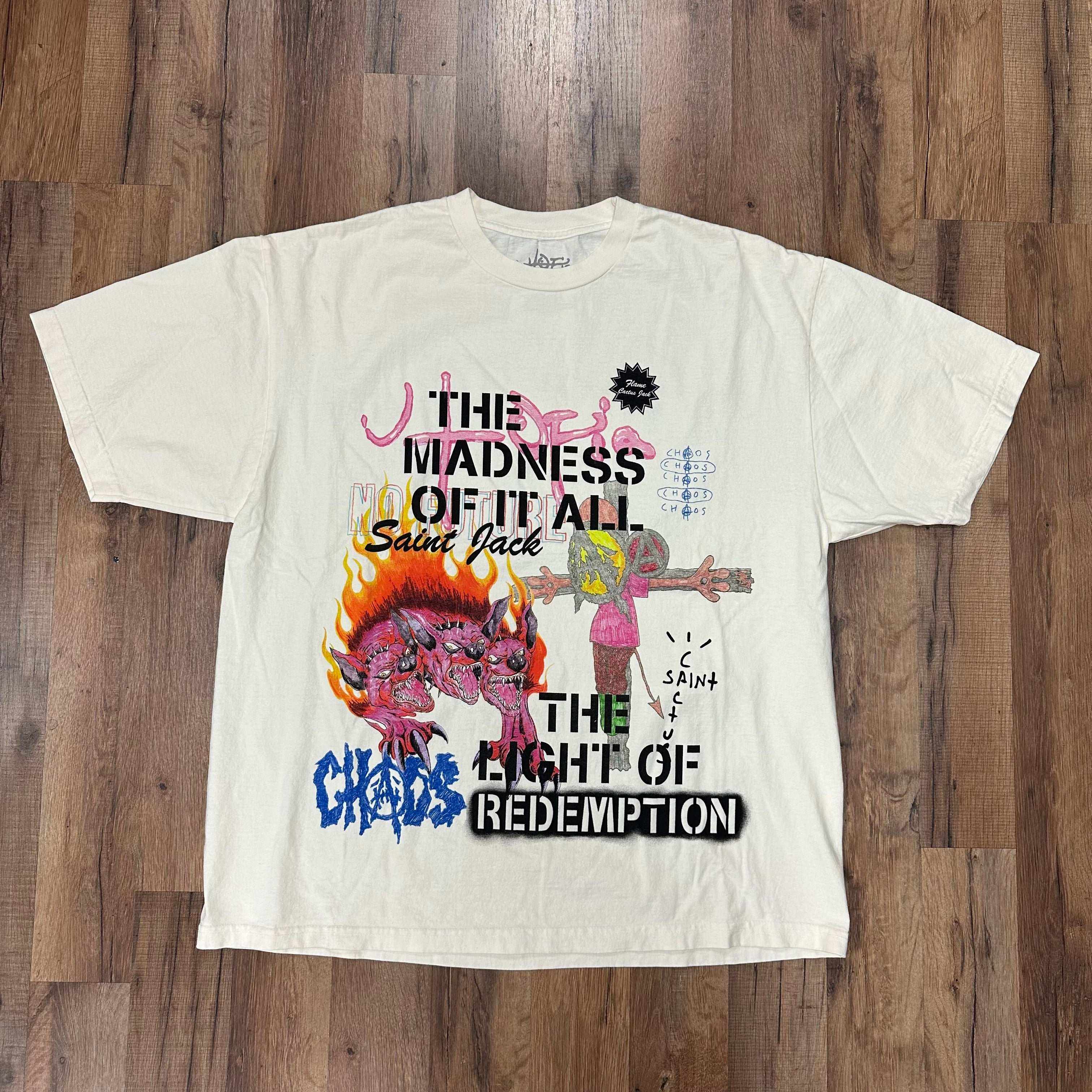White Travis Scott Utopia x St Michael 3A Tee with graphic text and colorful illustrations laid flat on wooden floor