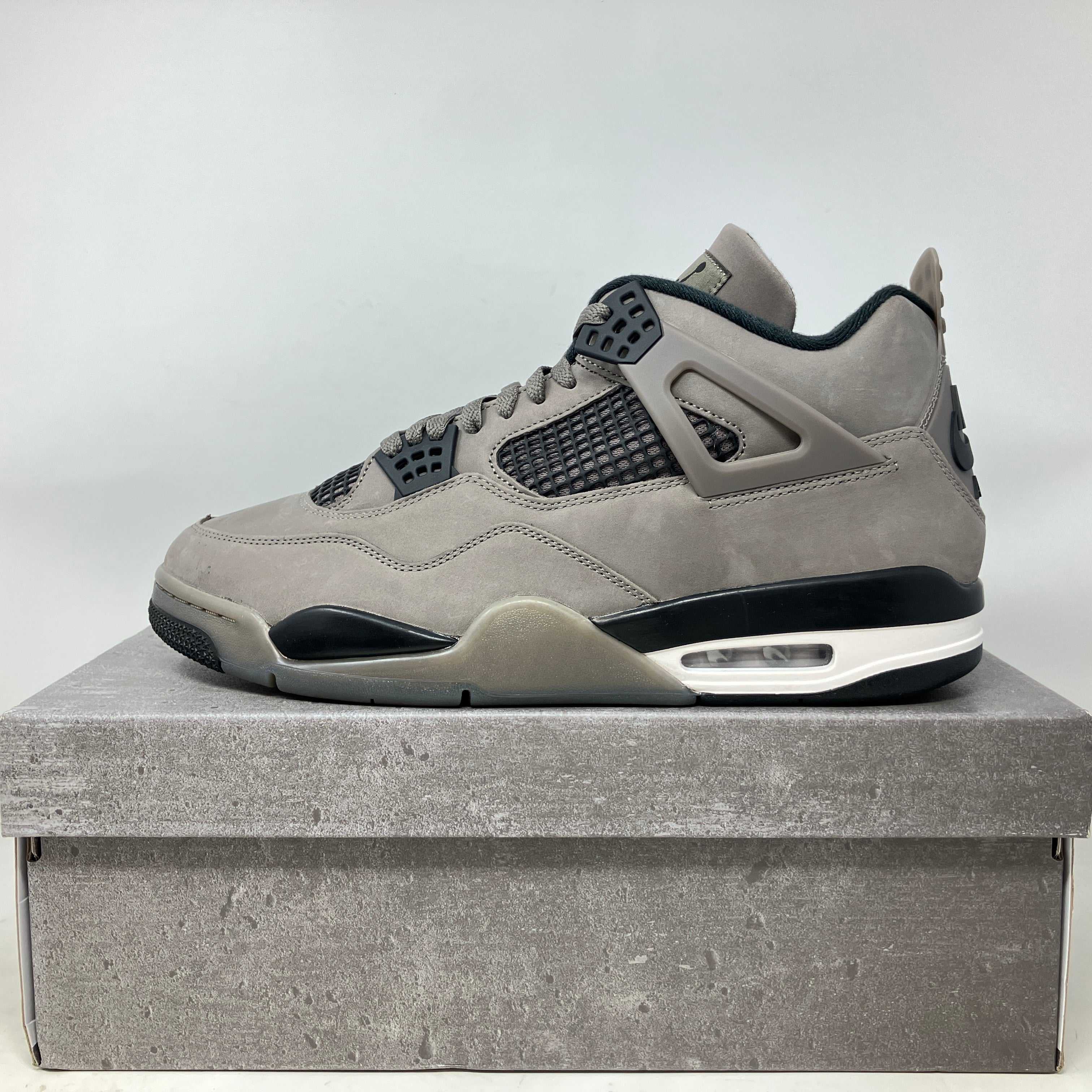 Jordan 4 Retro Cave Stone sneaker in grey with black accents on a matching stone-colored box