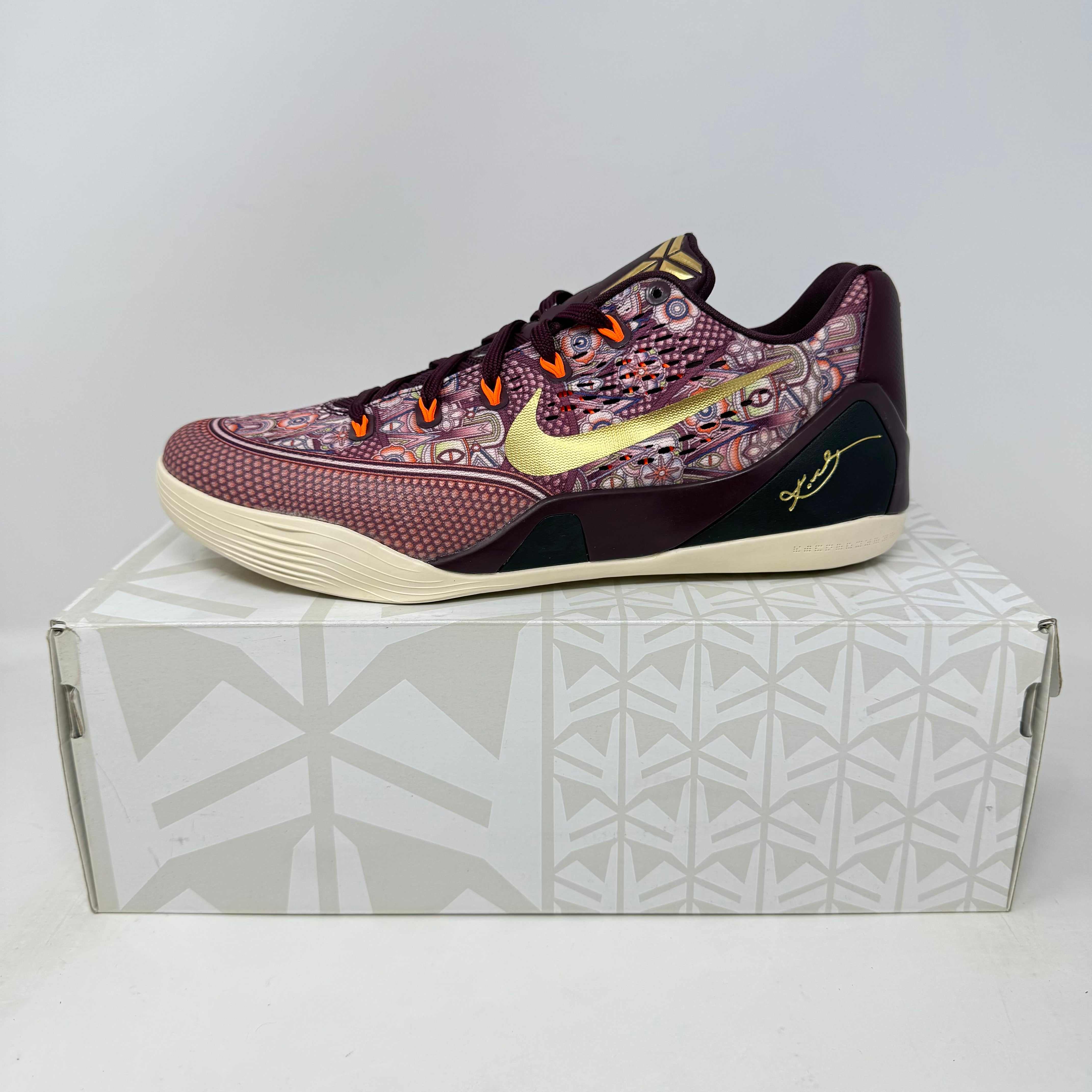 Nike Kobe 9 EM Low Silk basketball shoe in maroon with gold accents on a white patterned box