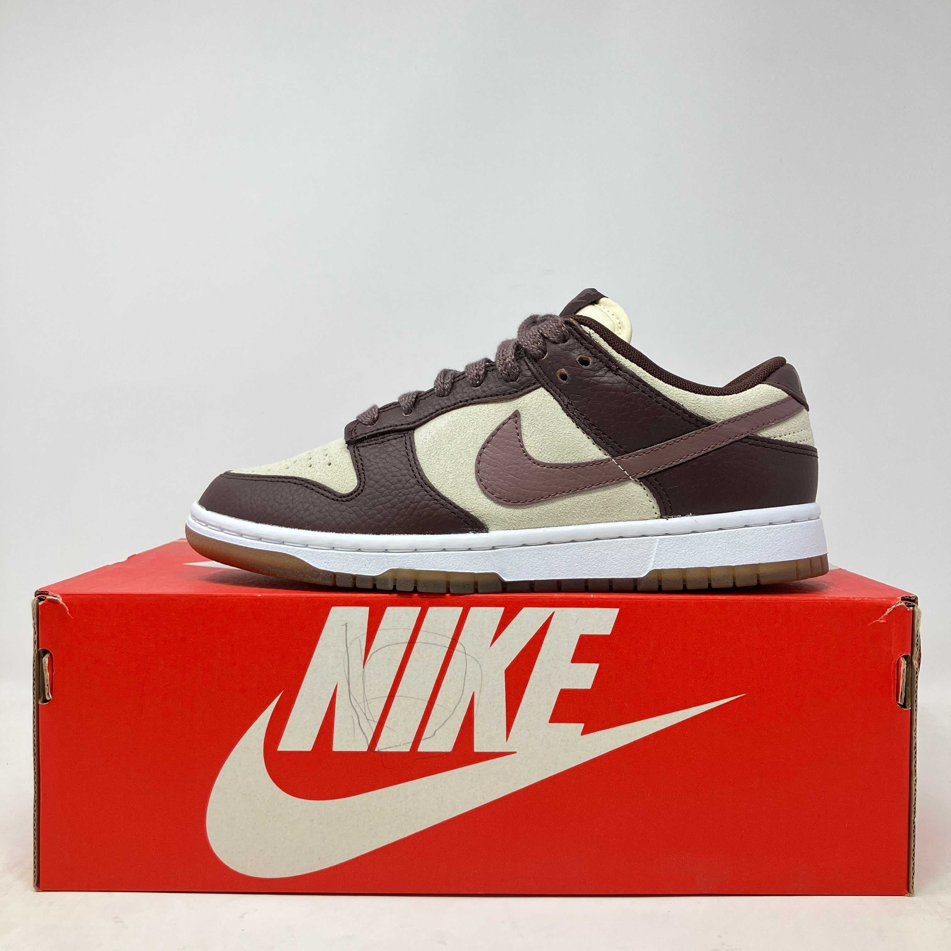Women's Nike Dunk Low Plum Eclipse sneakers on red Nike box.