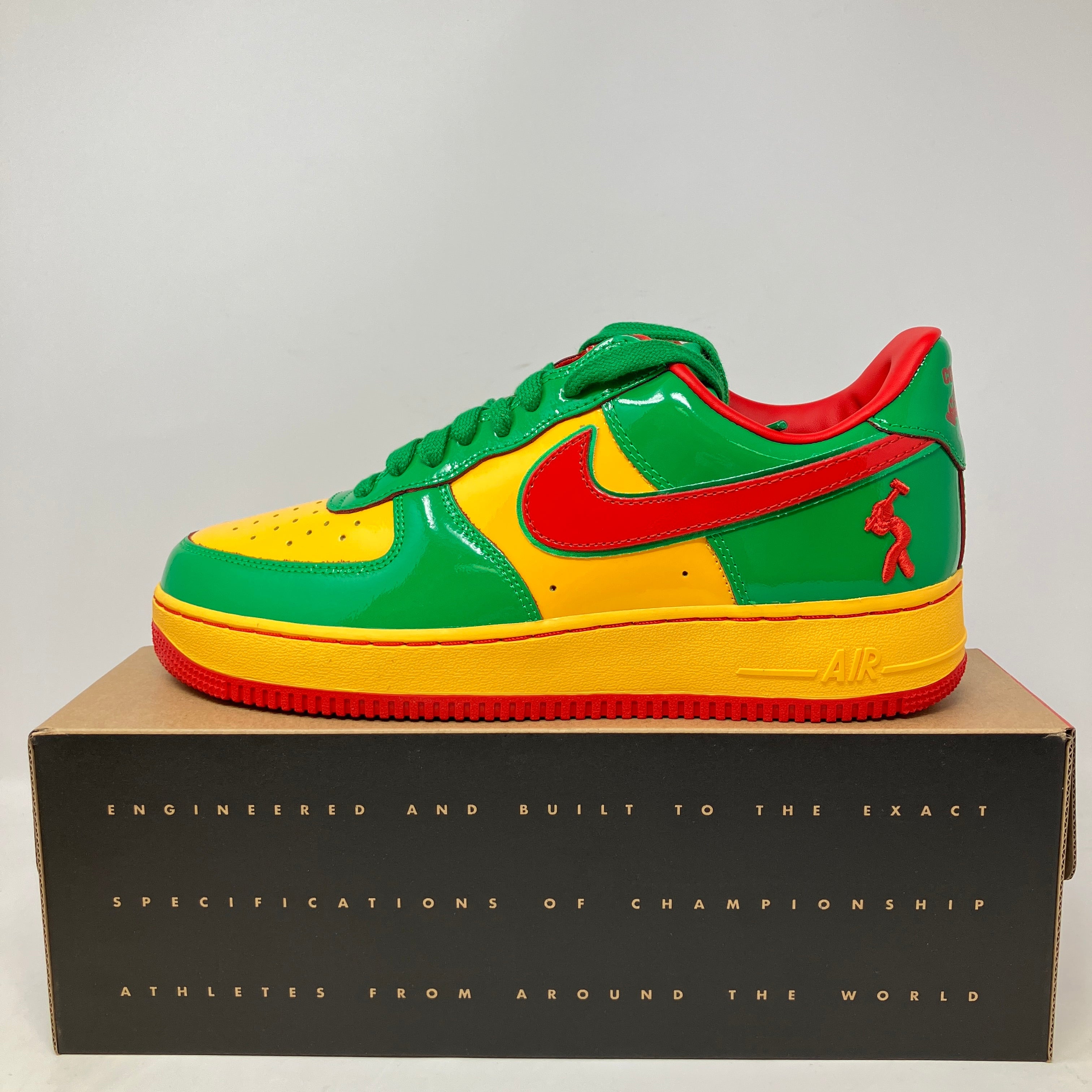 Nike Air Force 1 Low Lil Yachty Concrete Boys Lucky Green sneaker in green, yellow, and red on display box.