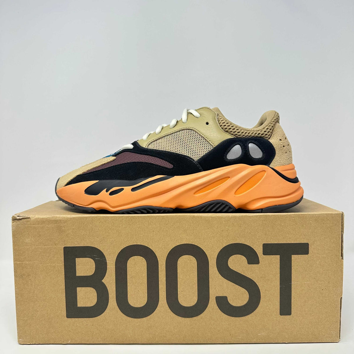 adidas Yeezy Boost 700 sneaker in enflame amber with beige, black, and orange suede and mesh materials on a BOOST box
