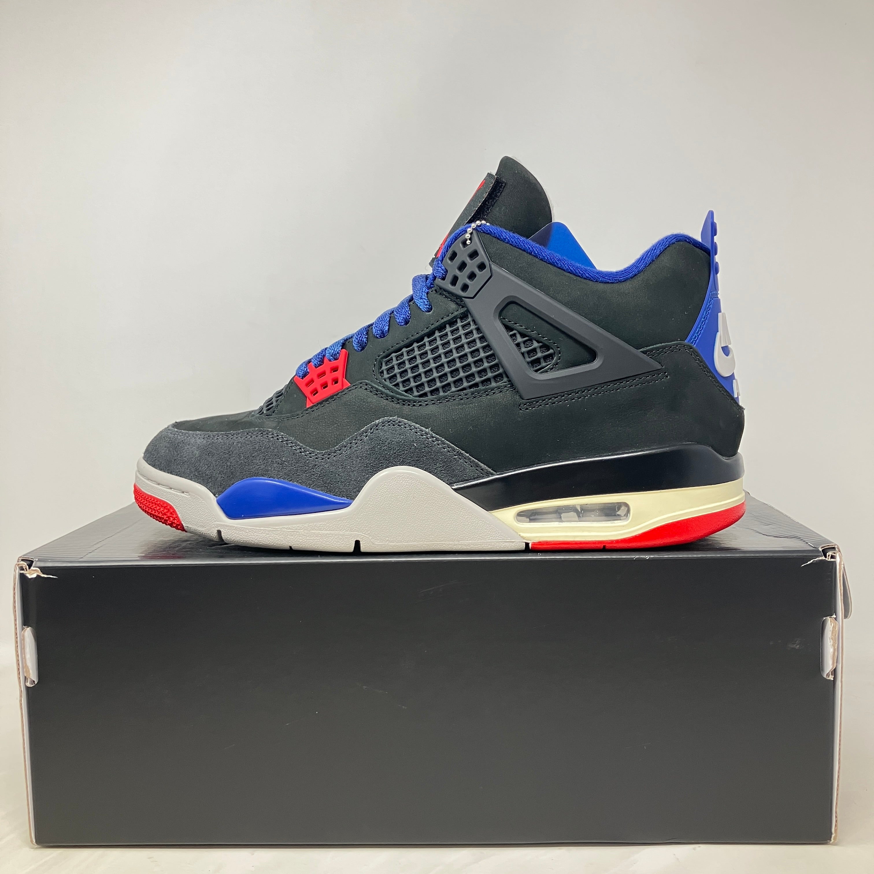 Jordan 4 Retro Rare Air sneaker in black, blue, red, and white on box, pre-owned condition with accessories included