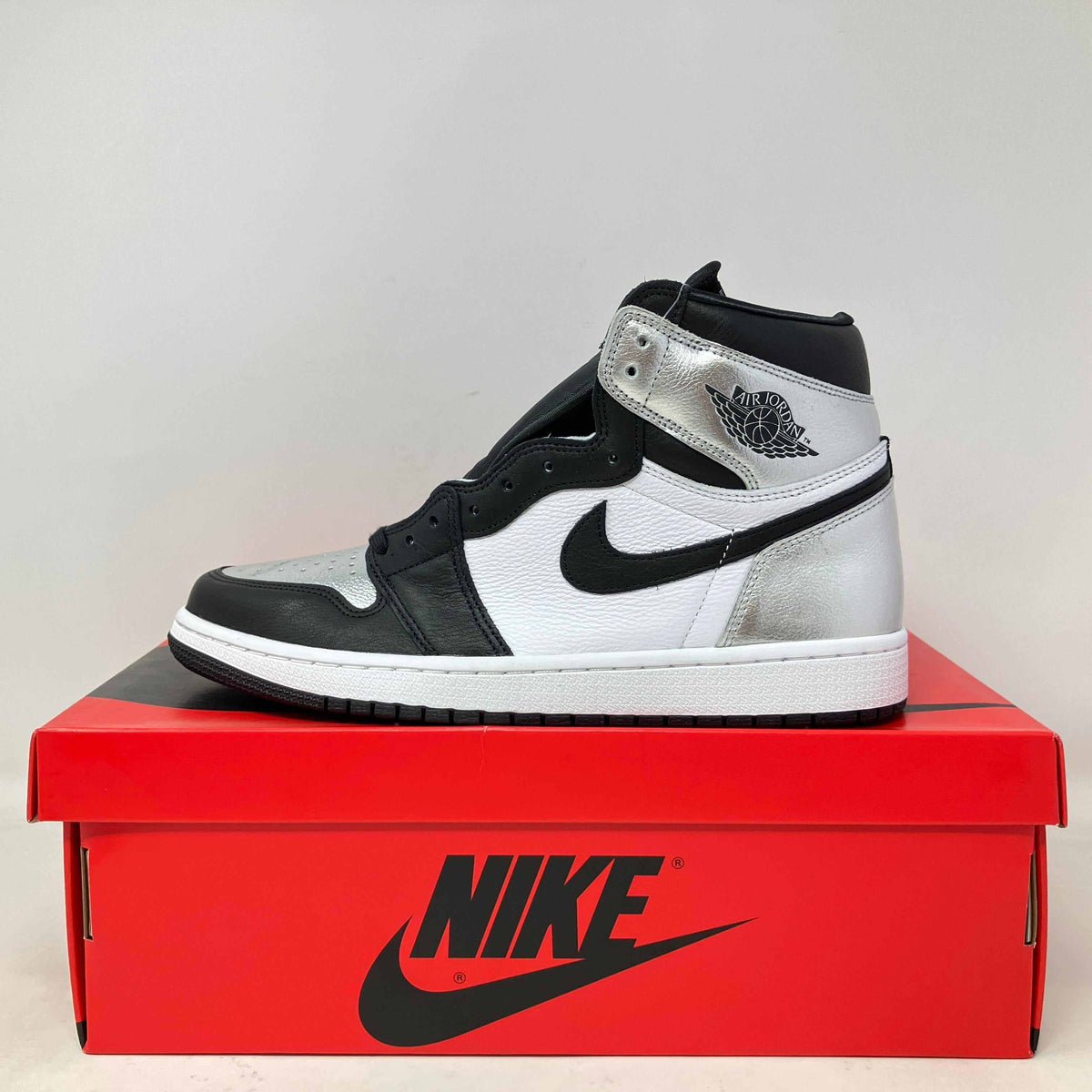 Jordan 1 Retro High Silver Toe women's sneaker in black, white, and silver leather with signature Nike swoosh and Wings logo