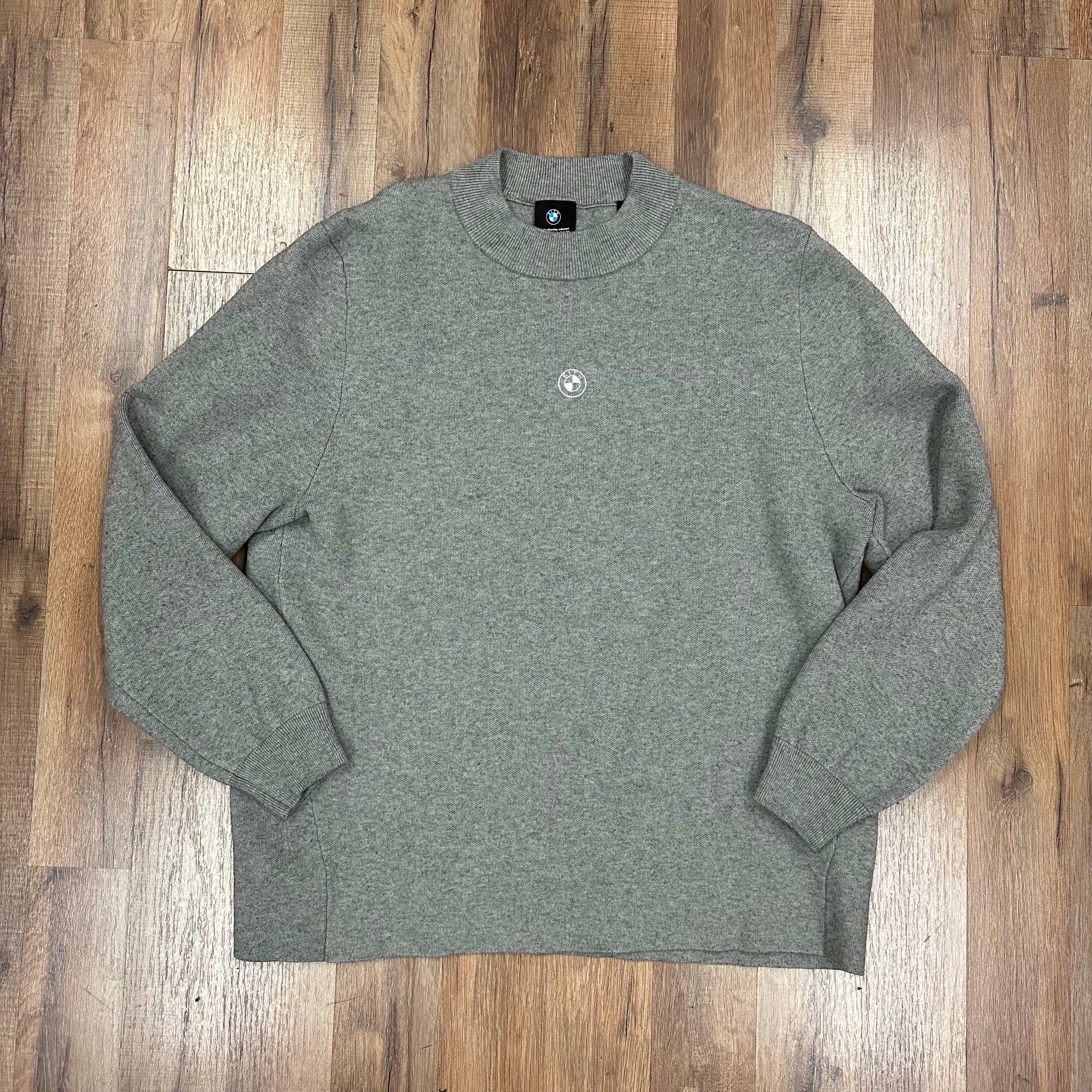 Kith x BMW knit mockneck sweater in heather grey laid flat on wooden floor