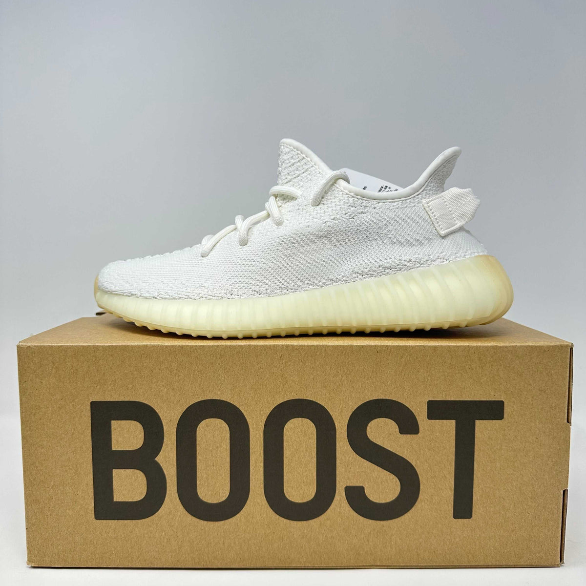 adidas Yeezy cream knit low-top sneaker with ribbed translucent sole and tonal laces on a brown BOOST box
