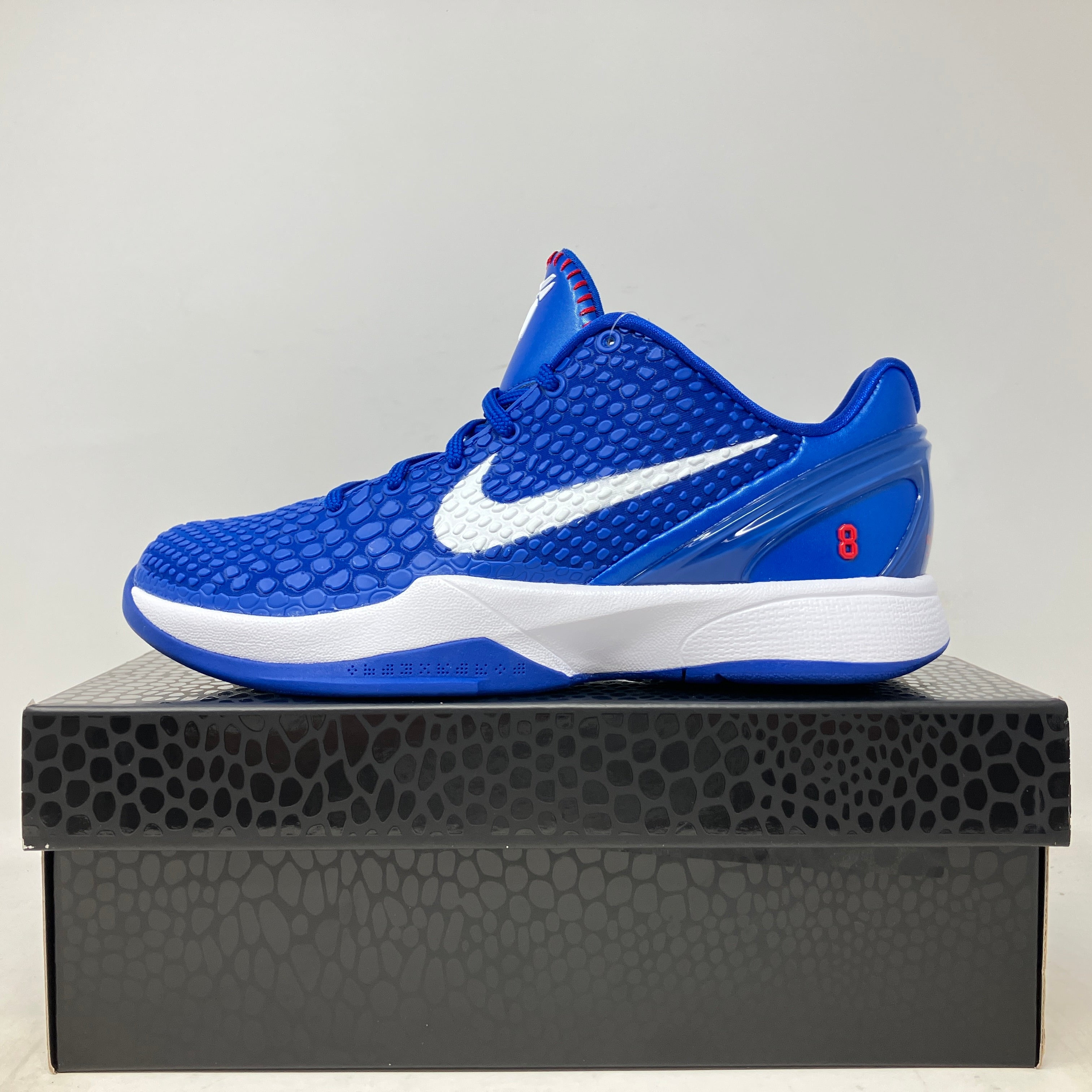 Blue Nike Kobe 6 Dodgers GS sneakers on black textured box.