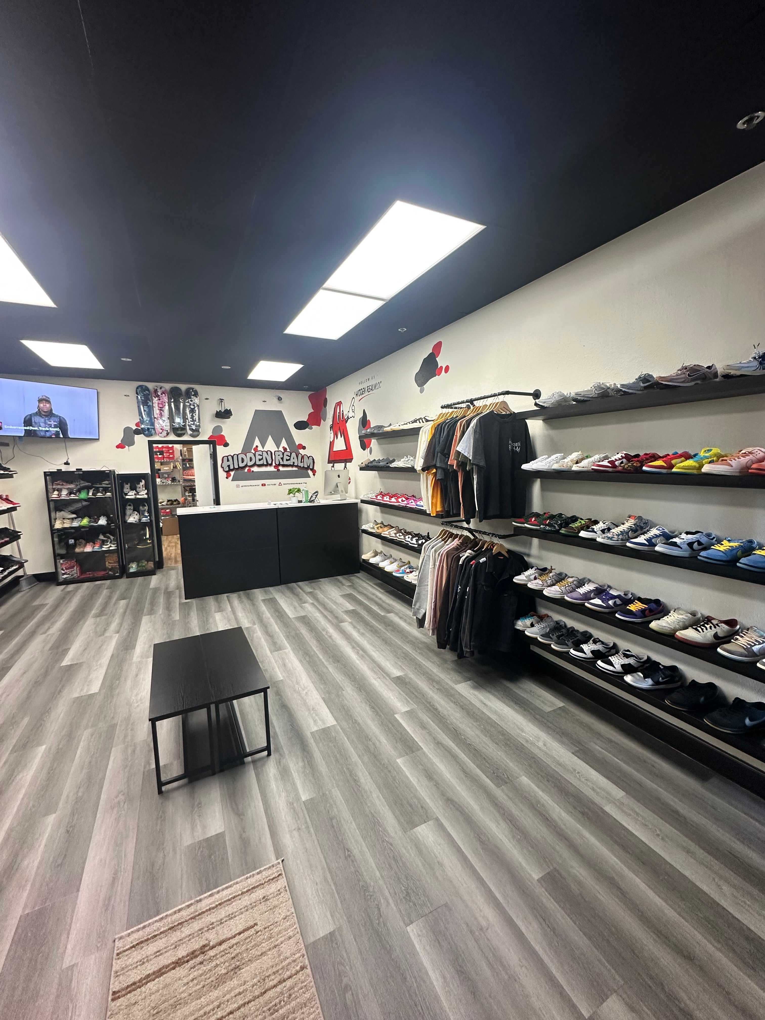 Interior view of Hidden Realm Sneaker Shop with shelves of Jordans, SB Dunks, and Yeezys for resale