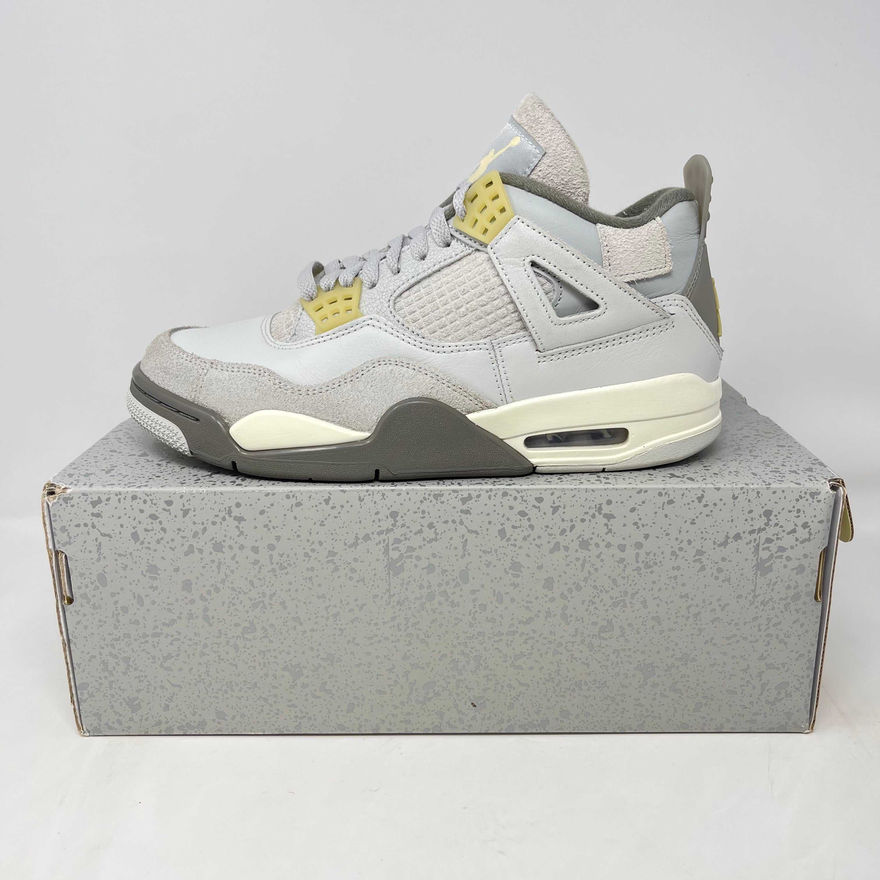 Side view of a gray and yellow Air Jordan 4 sneaker on a gray speckled shoebox, trendy sneaker drop for SoCal sneakerheads 2025
