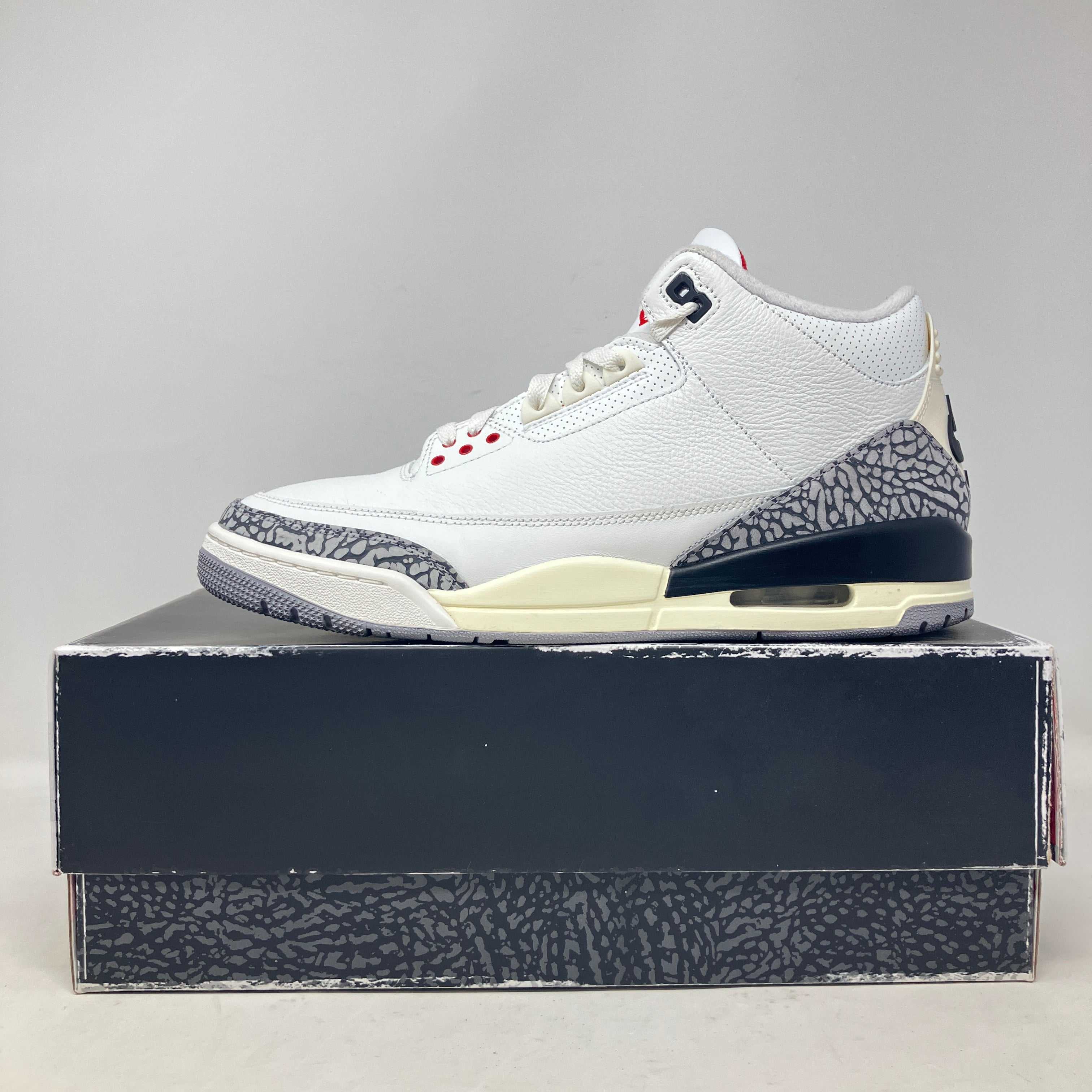 Side view of pre-owned Jordan 3 Retro White Cement sneaker on box with all accessories included