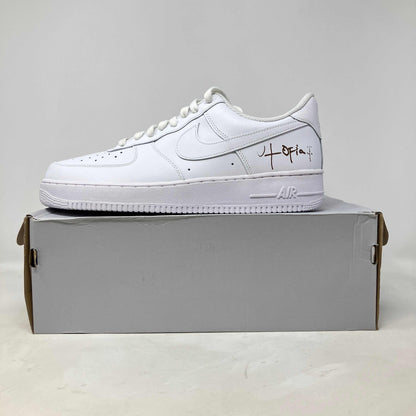 White Nike Air Force 1 Low '07 sneaker with signature detail, displayed on a gray box