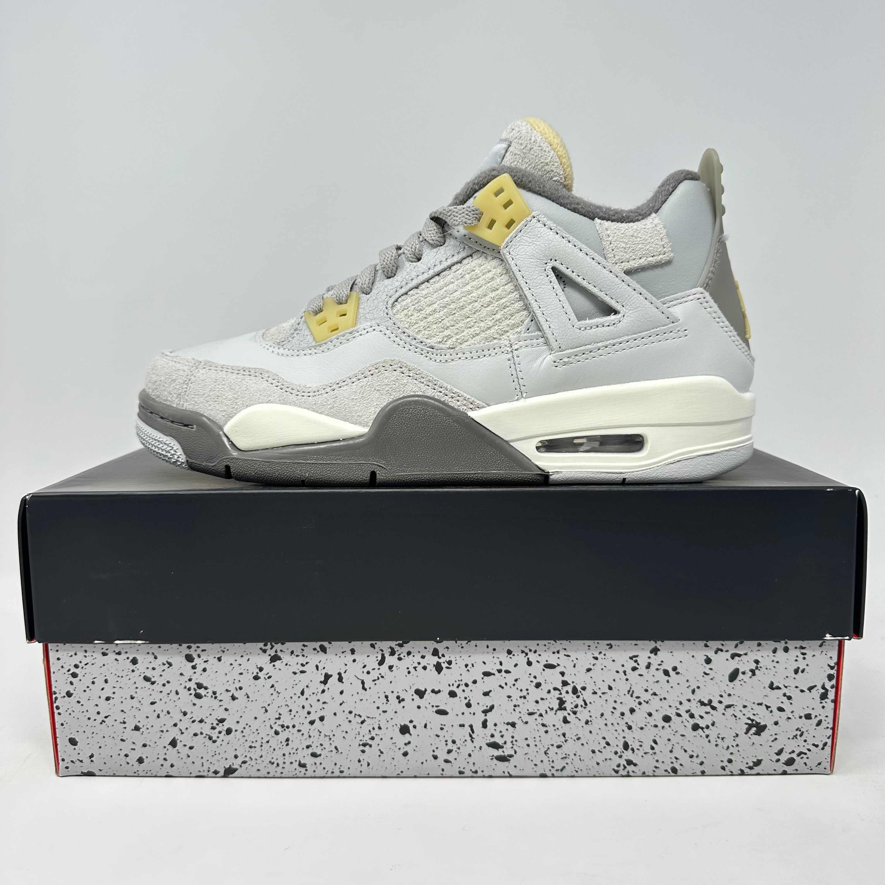 Jordan 4 Retro SE Craft Photon Dust sneaker in white and grey on speckled box, brand new with accessories included