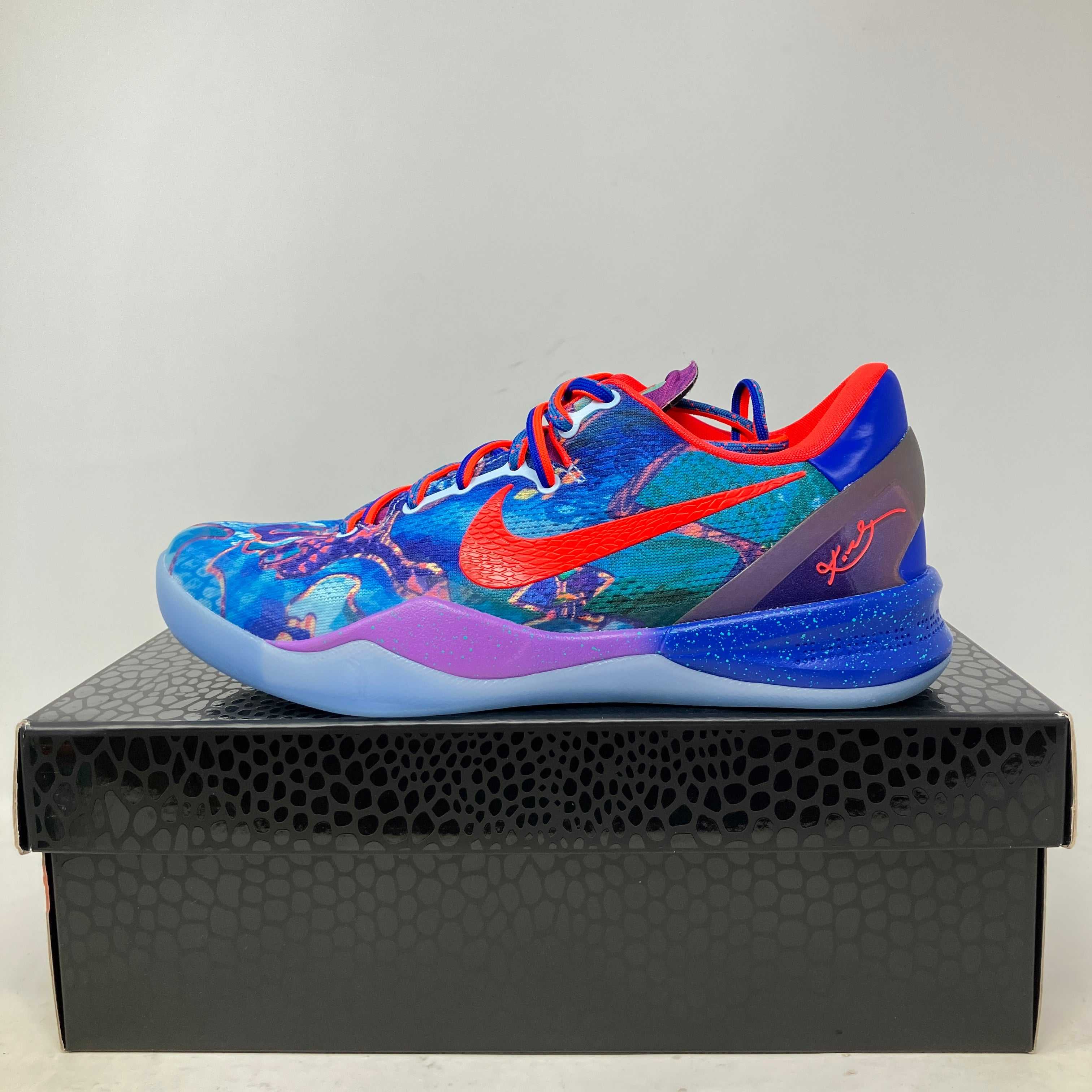 Nike Kobe 8 Protro What The sneaker in vibrant blue, red, and purple colors, pre-owned with all accessories on black textured shoe box