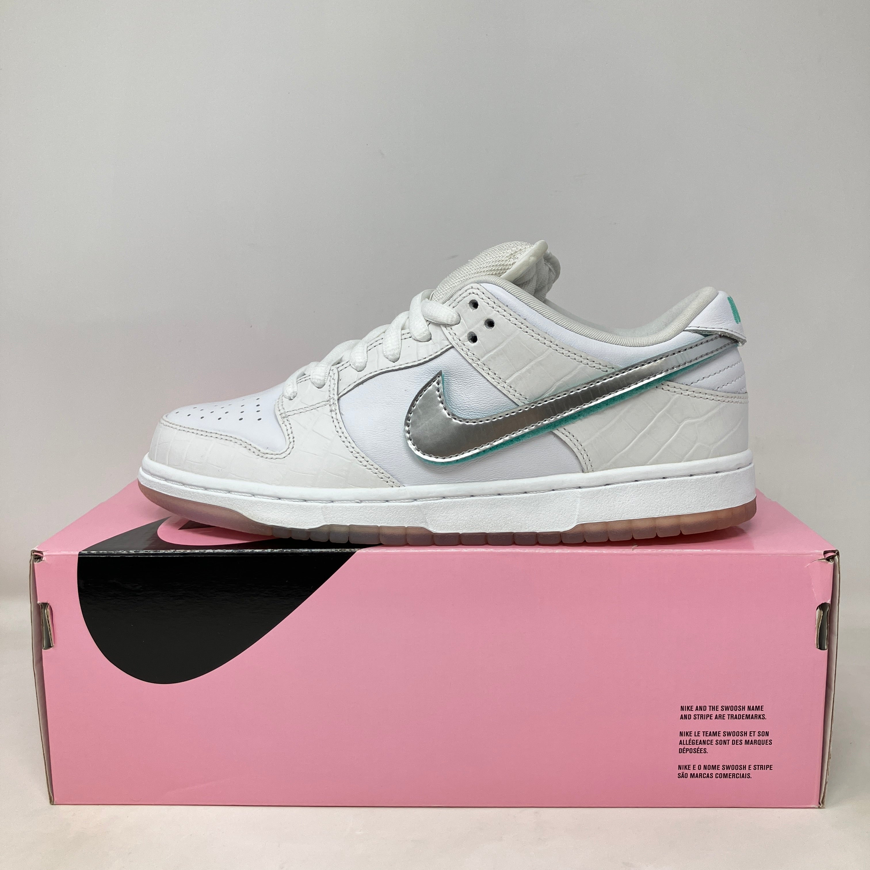 Nike SB Dunk Low Diamond Supply Co. White sneaker with silver swoosh on pink box