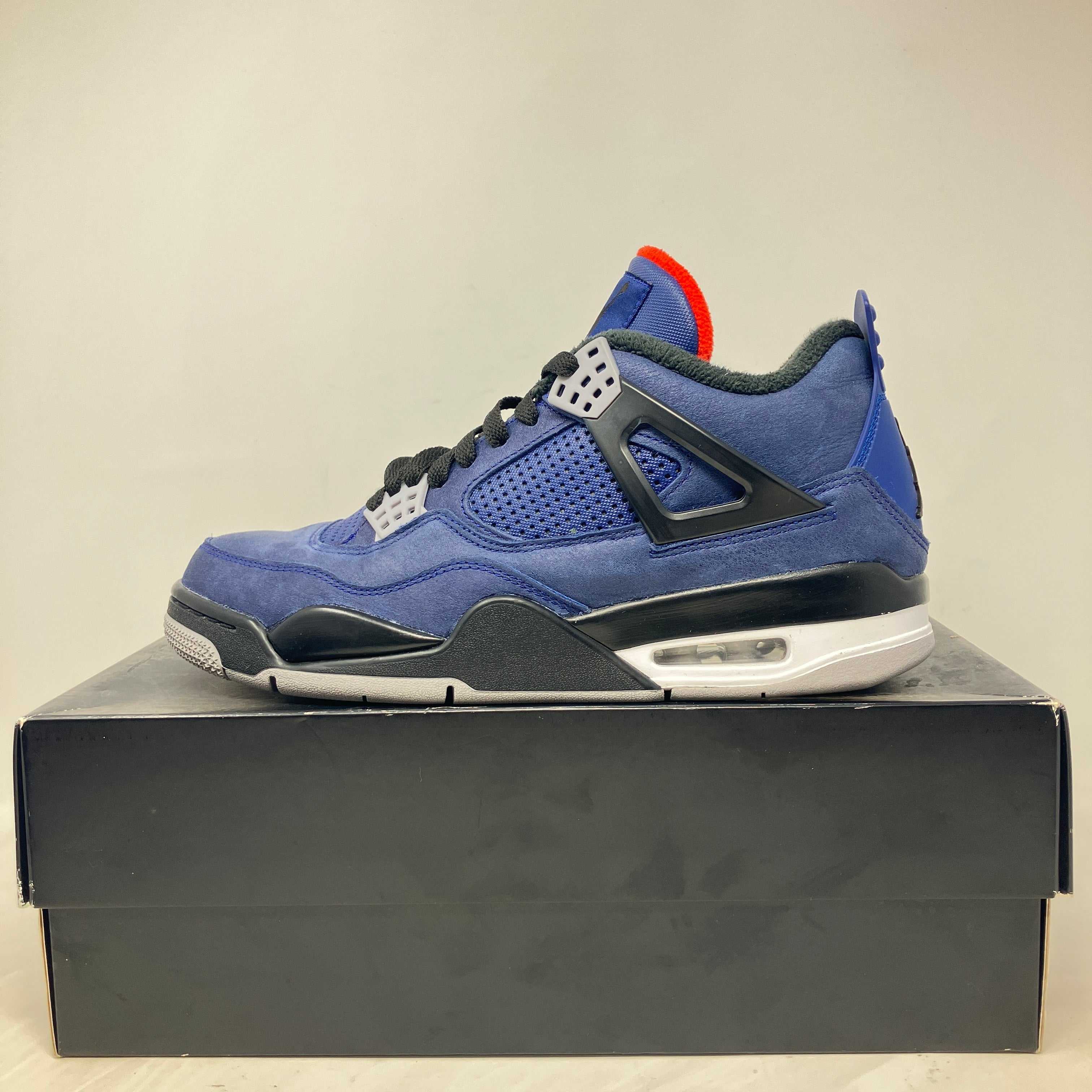 Jordan 4 Retro Winterized Loyal Blue sneaker on black replacement box, pre-owned condition