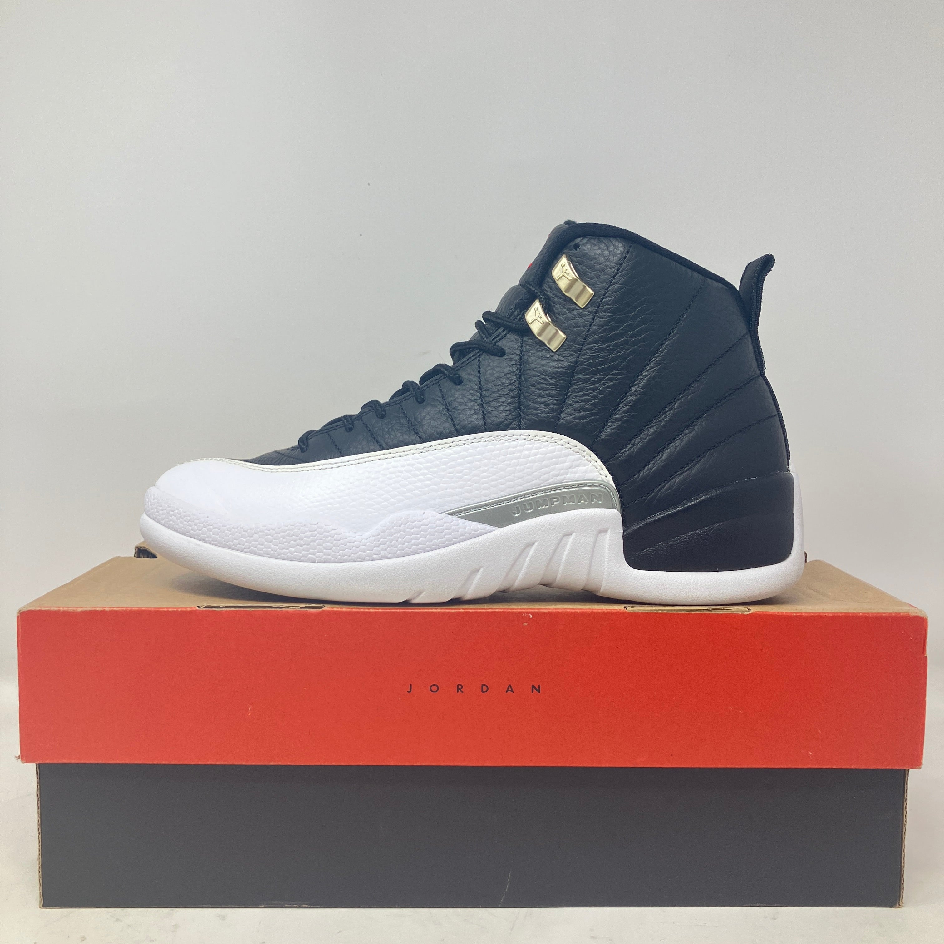 Black and white Jordan 12 Retro Playoffs sneaker on box, pre-owned condition with all accessories included