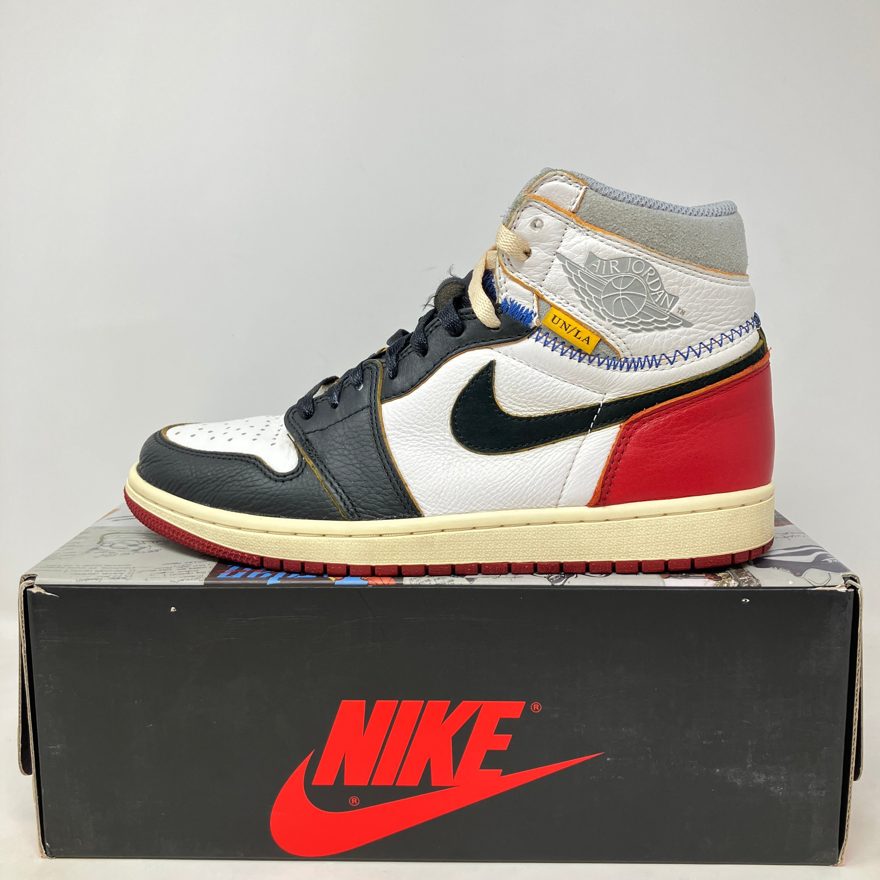 Jordan 1 Retro High Union Los Angeles Black Toe sneaker on Nike box, pre-owned with missing yellow extra laces.