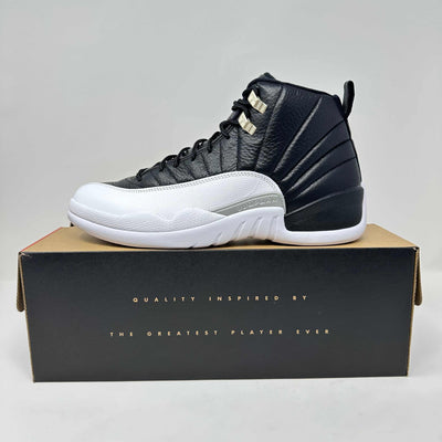 Jordan 12 Retro Playoffs high-top sneaker in black and white leather, with gold lace eyelets and sculpted sole.