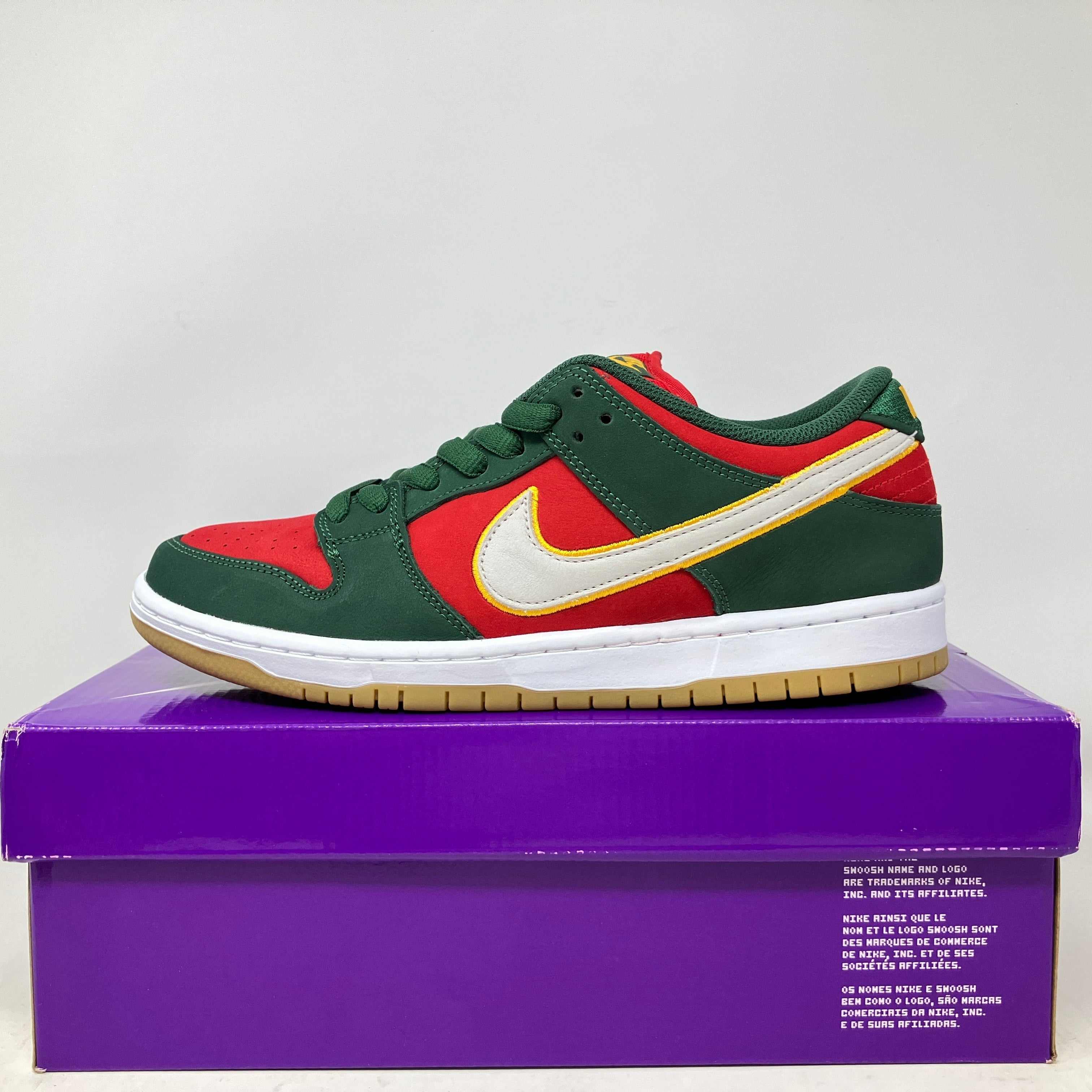 Nike SB Dunk Low Pro PRM Seattle Supersonics sneaker in green, red, and yellow on purple shoe box