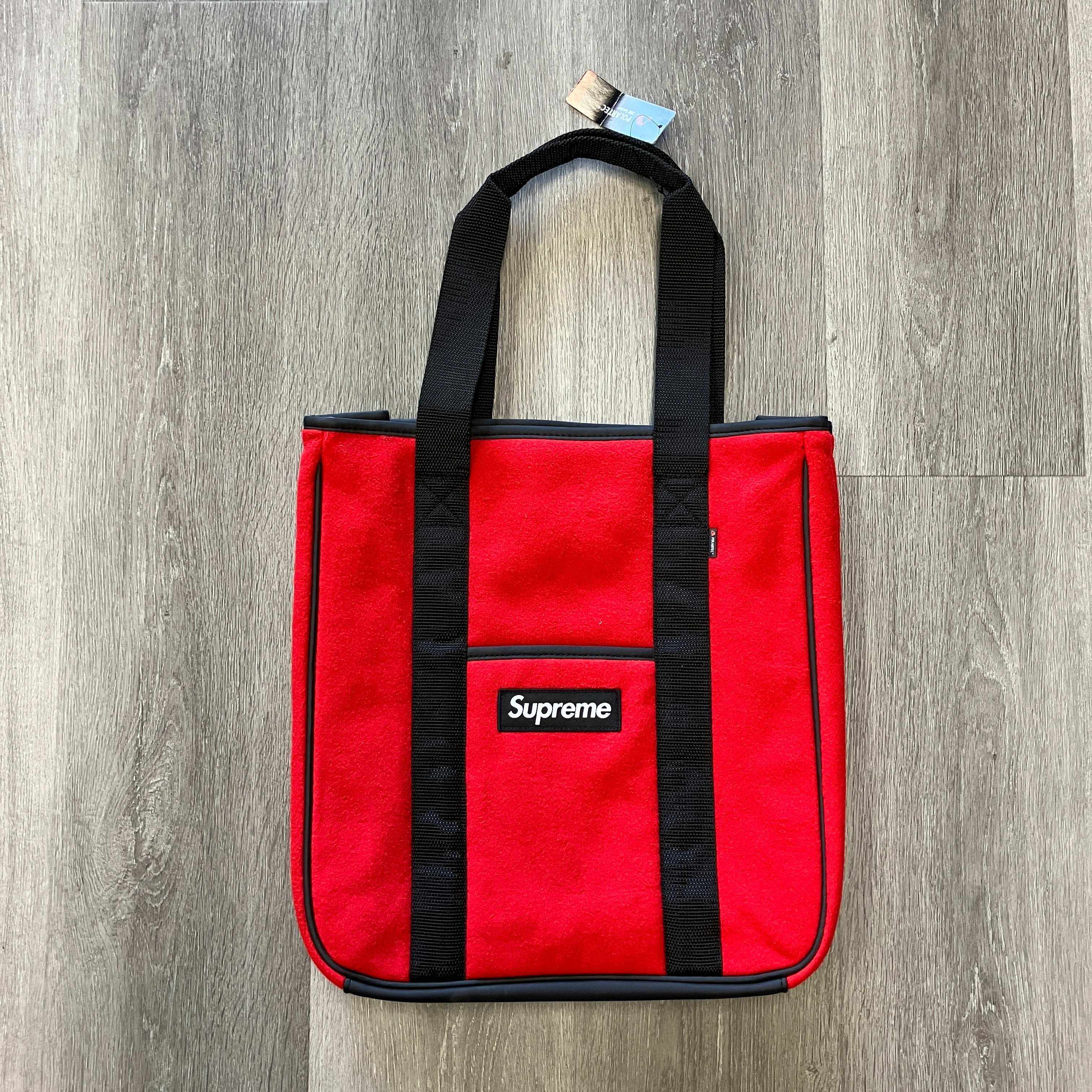 Red Supreme Polartec tote bag with black handles and logo patch on front