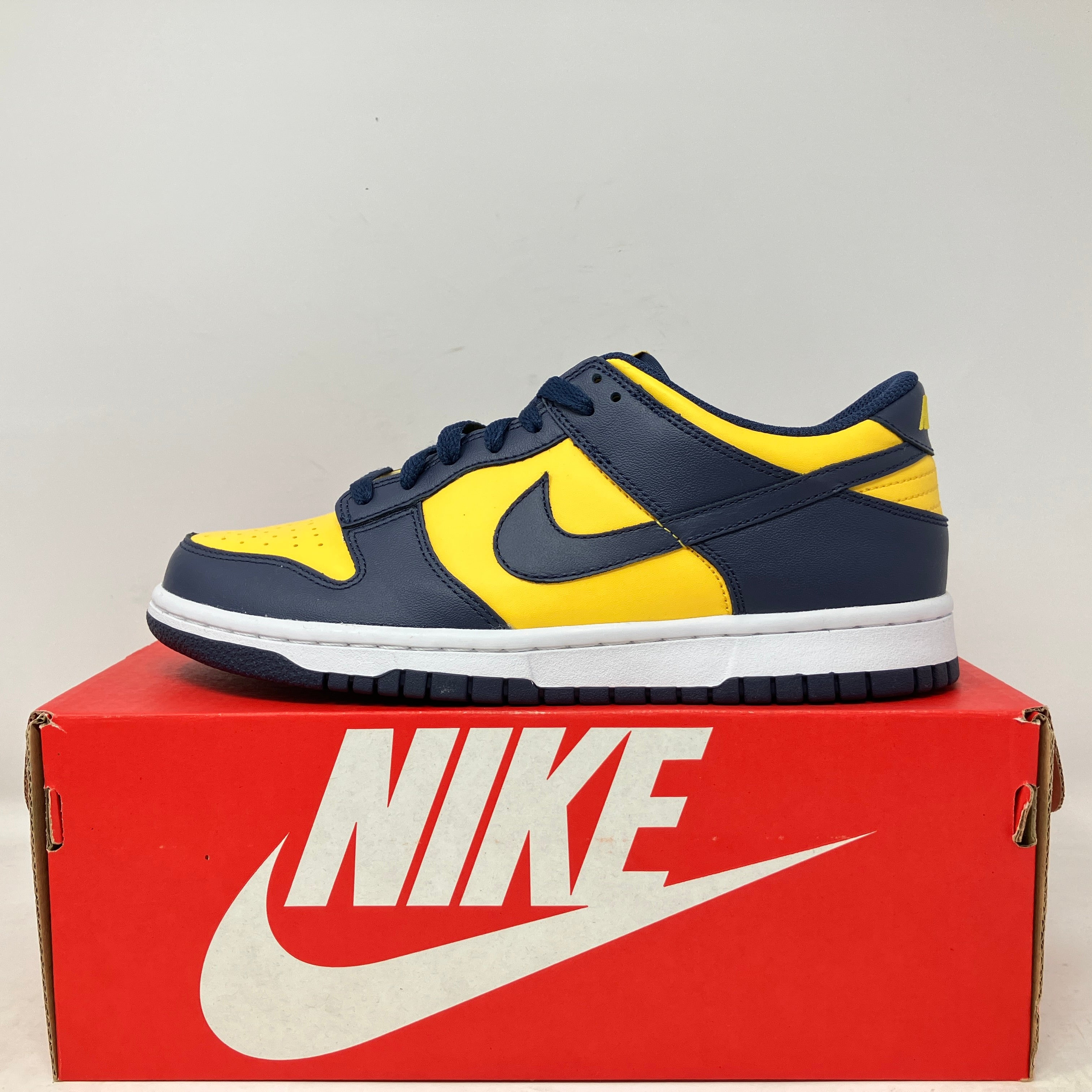Nike Dunk Low Michigan GS sneaker in yellow and navy blue on red Nike box, brand new with accessories included