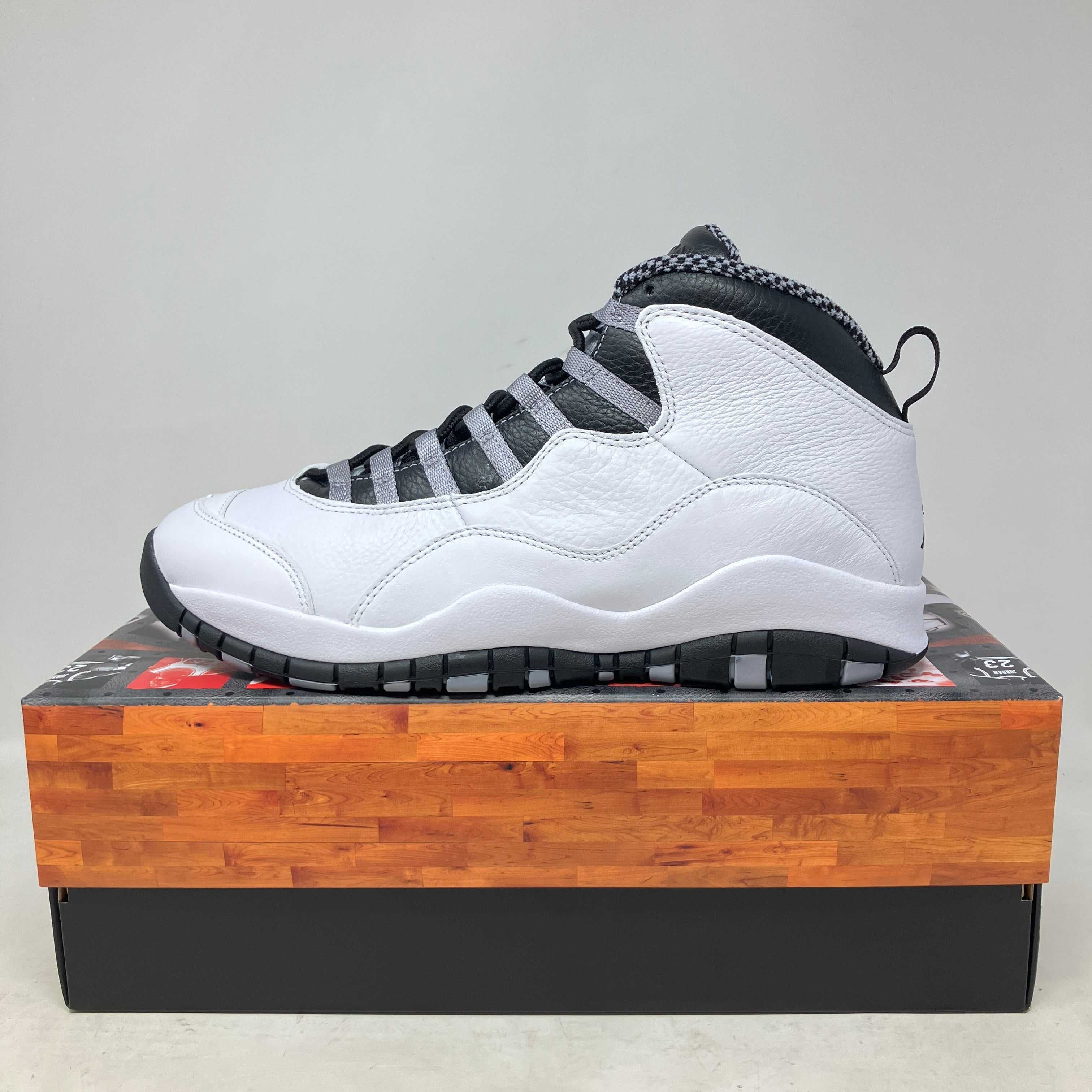 Side view of brand new Jordan 10 Retro OG Steel sneaker on shoebox with full accessories included