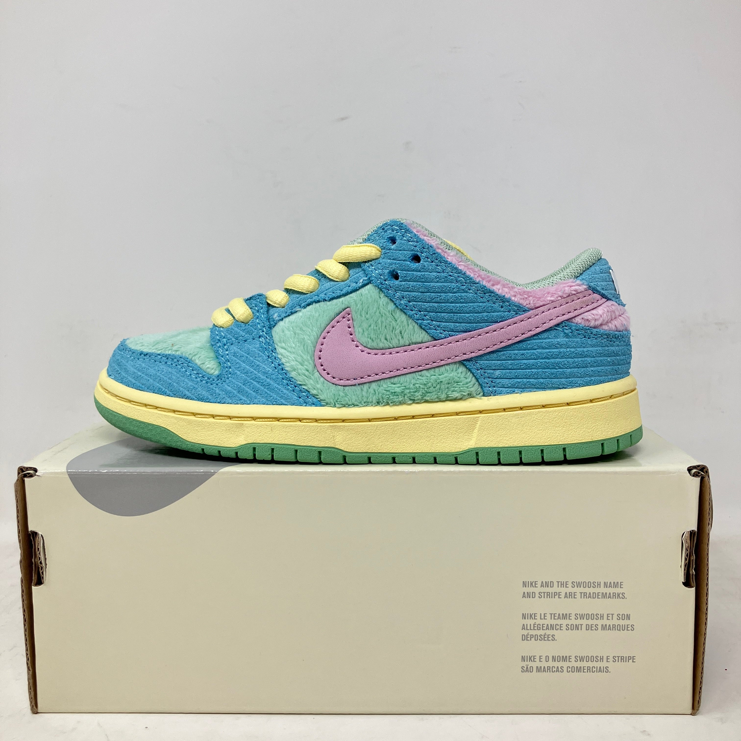 Nike SB Dunk Low Verdy sneakers in blue, pink, and yellow on box.
