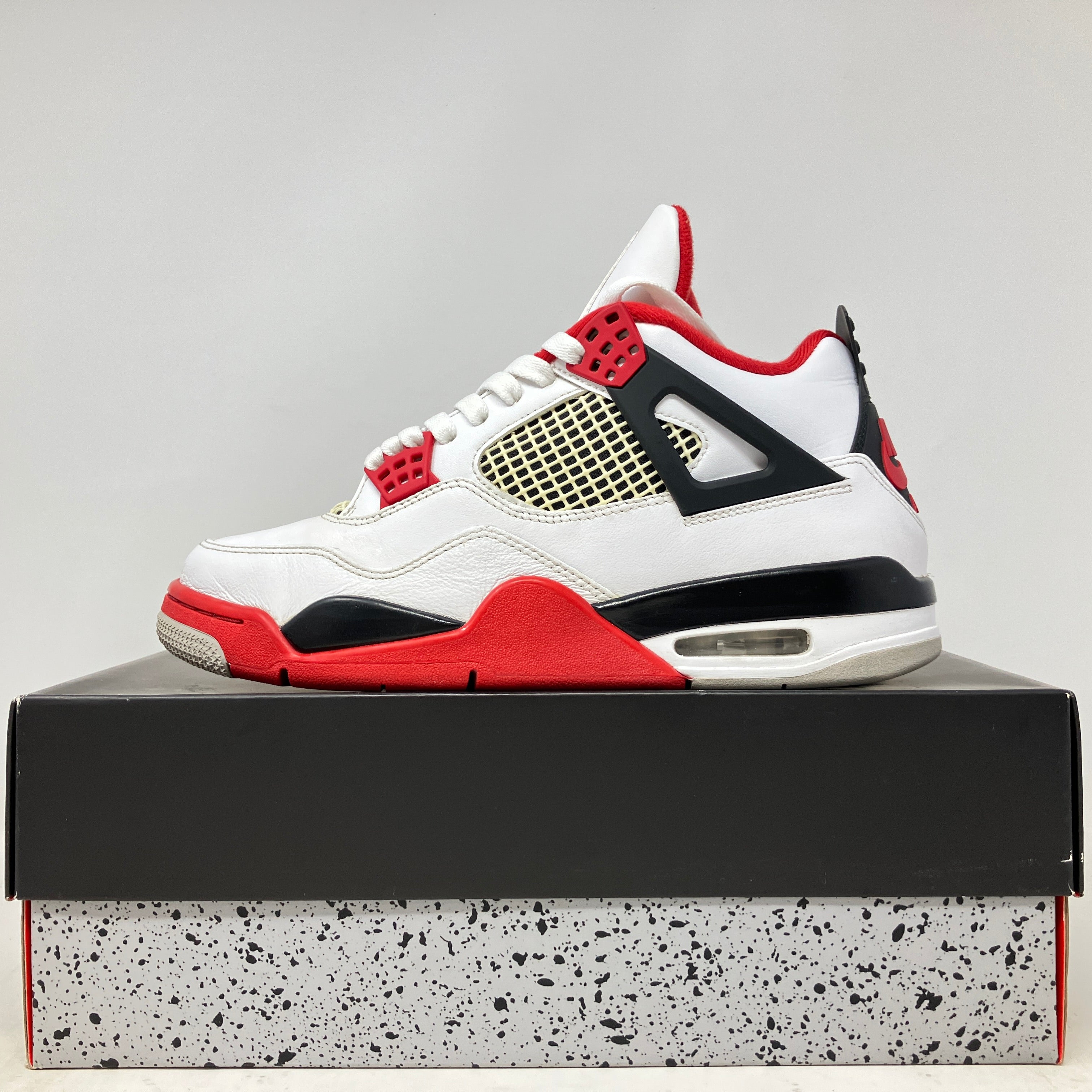 Jordan 4 Retro Fire Red 2020 sneaker in white, red, and black on its original box, pre-owned condition with accessories included.