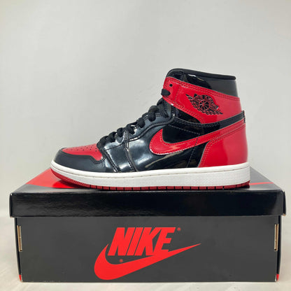 Jordan 1 Retro High OG Patent Bred sneaker on Nike box, pre-owned with accessories included